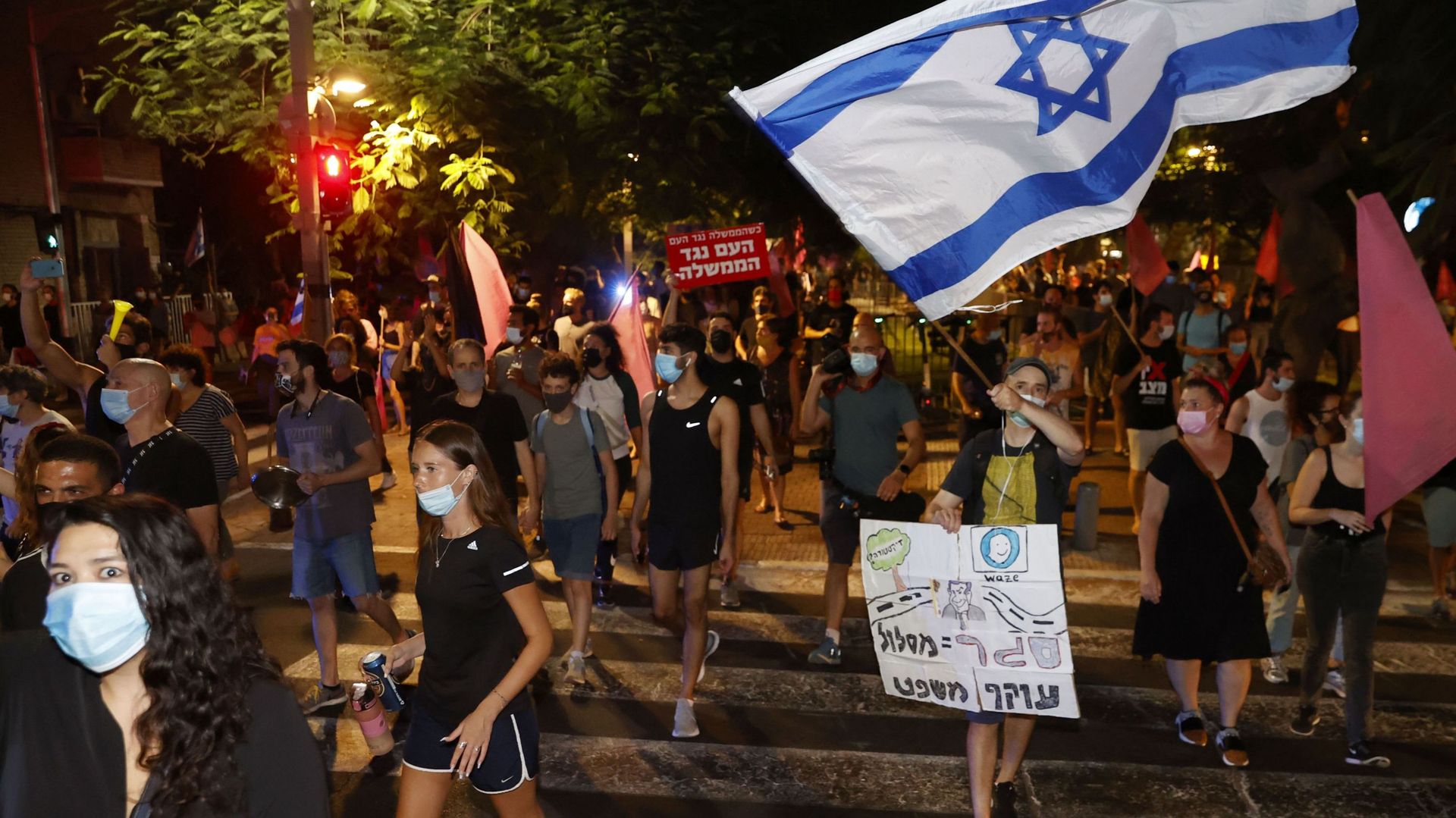 Des manifestants antigouvernementaux israéliens défilent lors d'une manifestation contre le Premier ministre Benjamin Netanyahu et son gouvernement, à Tel-Aviv, le 6 octobre 2020.
