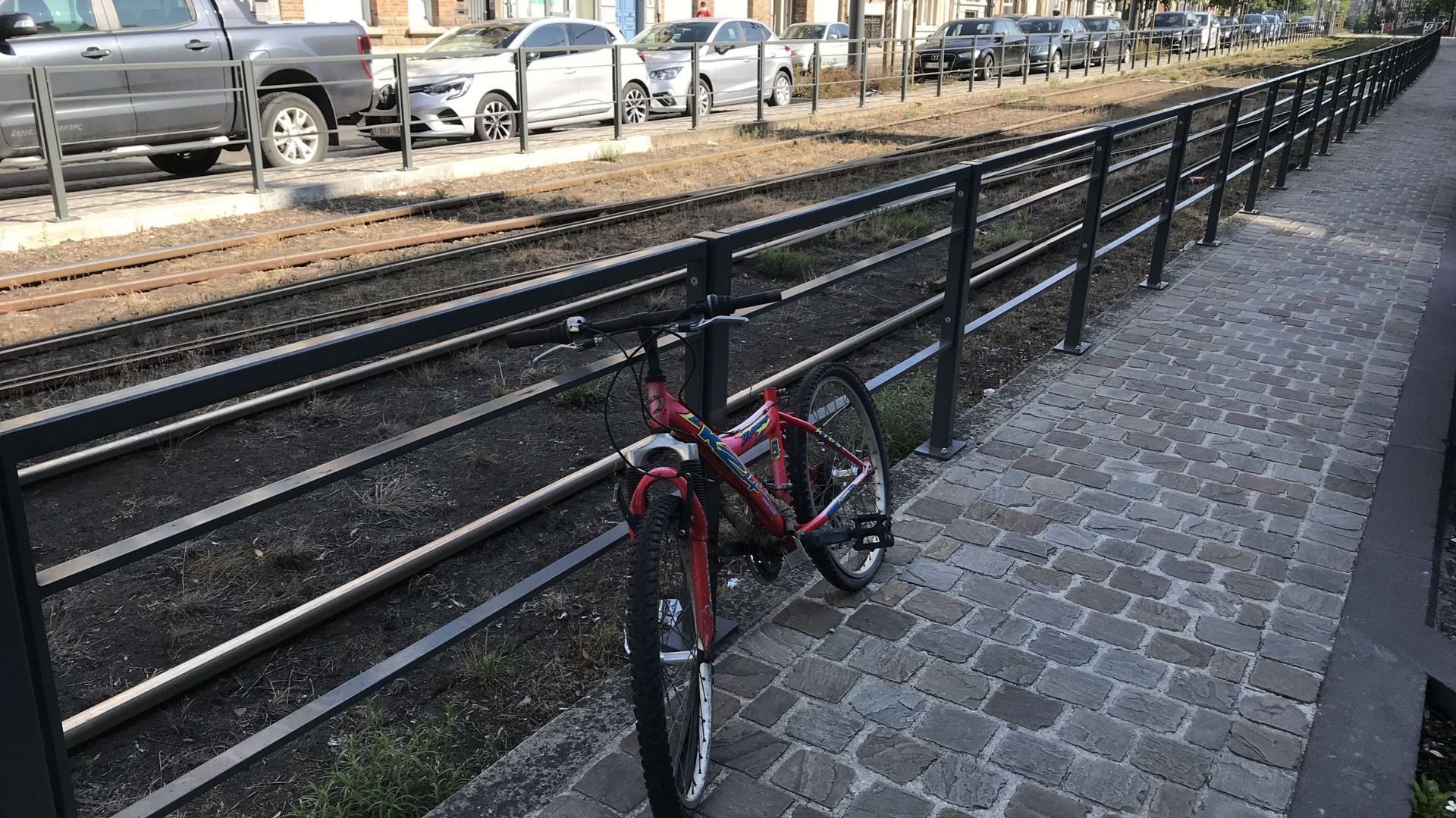Ce vélo rouge, accroché le long des rails de tram sur le Boulevard Général Jacques, a été retiré après avoir passé au moins un an sans bouger à cet endroit