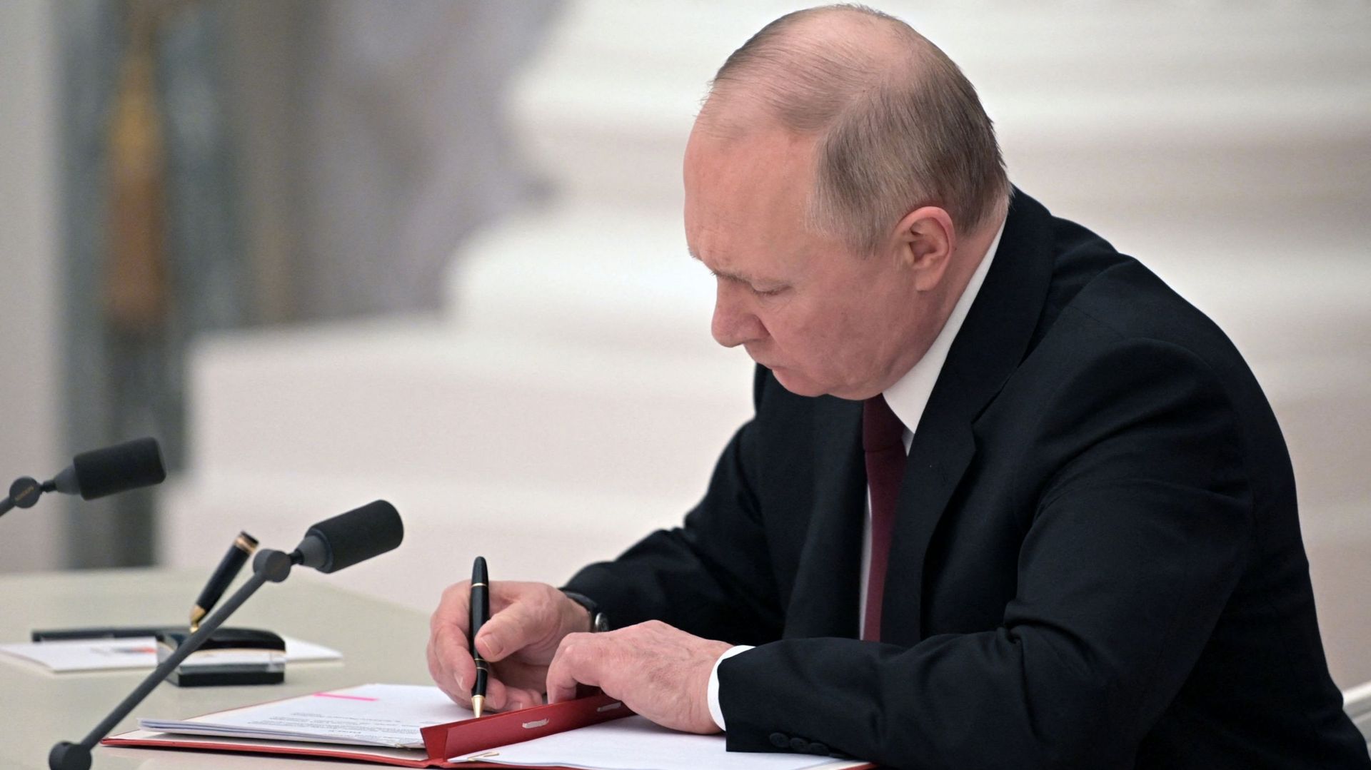 Le président russe Vladimir Poutine signe des documents, dont un décret reconnaissant deux régions sécessionnistes soutenues par la Russie dans l'est de l'Ukraine comme indépendantes, lors d'une cérémonie au Kremlin à Moscou le 21 février 2022. Alexeï NIK