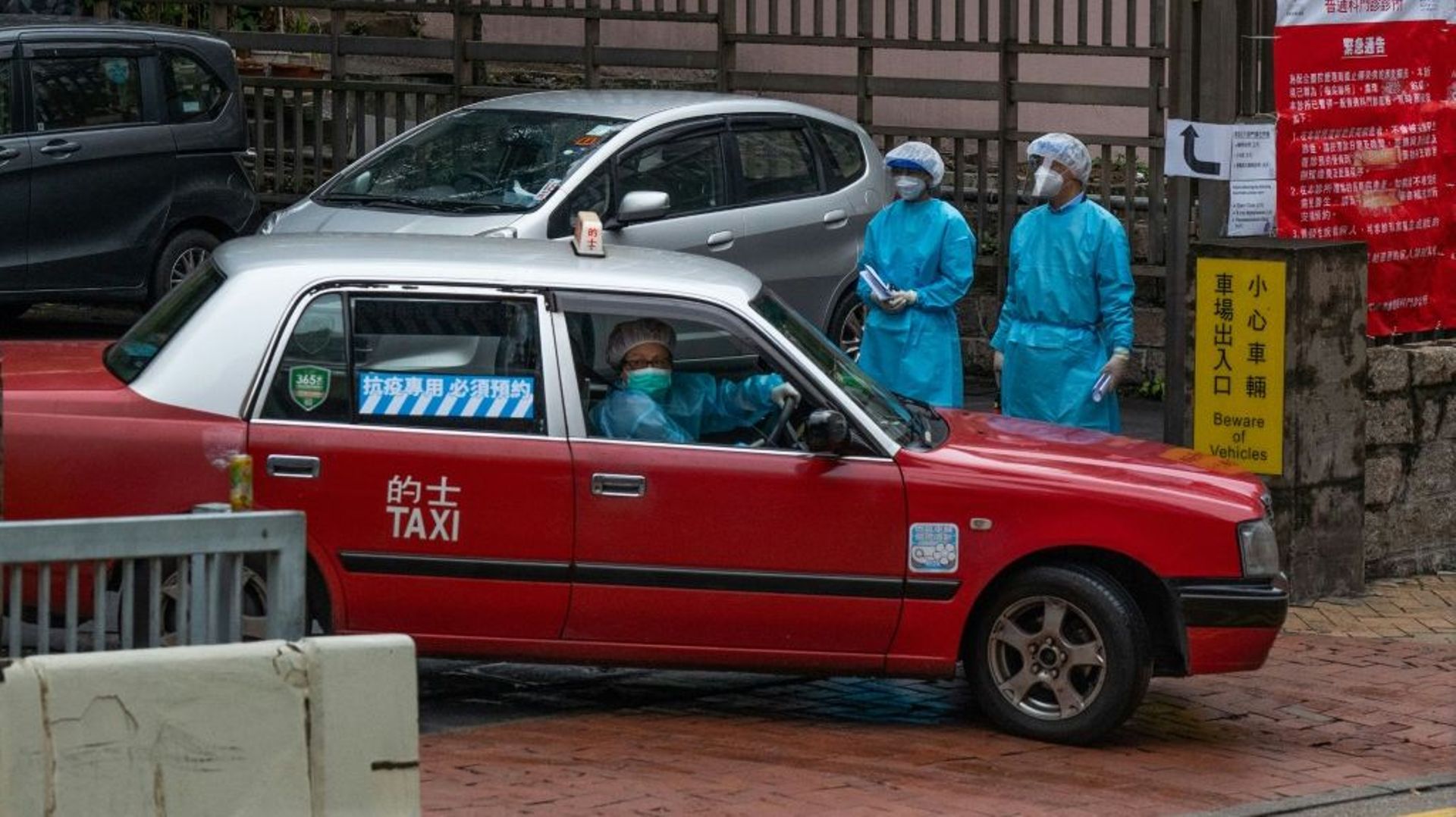 Un taxi dédié au transport des patients Covid-19 quitte une clinique dédiée dans le quartier de Shau Kei à Hong Kong le 19 février 2022