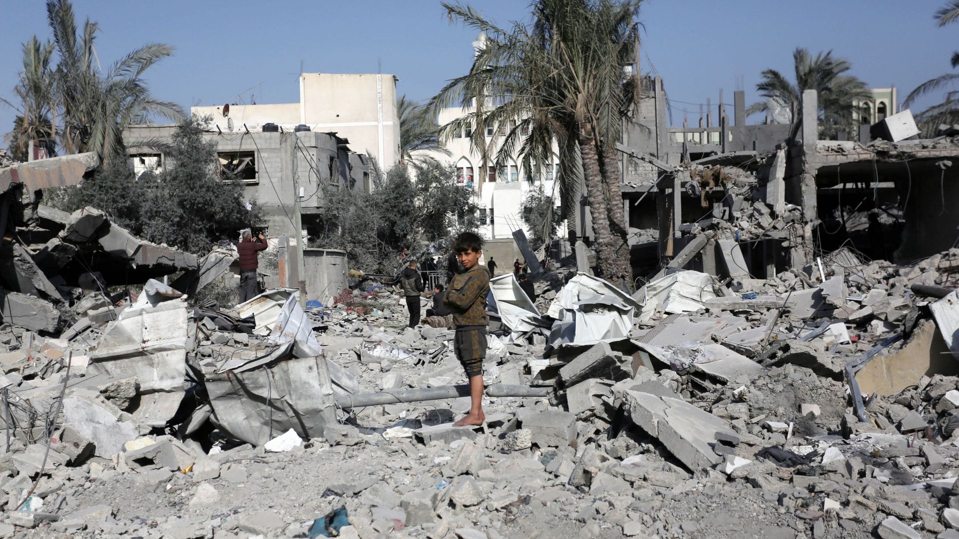 Un enfant est vu parmi les décombres alors que les résidents locaux mènent des efforts de recherche et de sauvetage parmi les décombres de l’immeuble détruit appartenant à la famille Abu Seif à la suite des attaques israéliennes contre un immeuble à Deir 