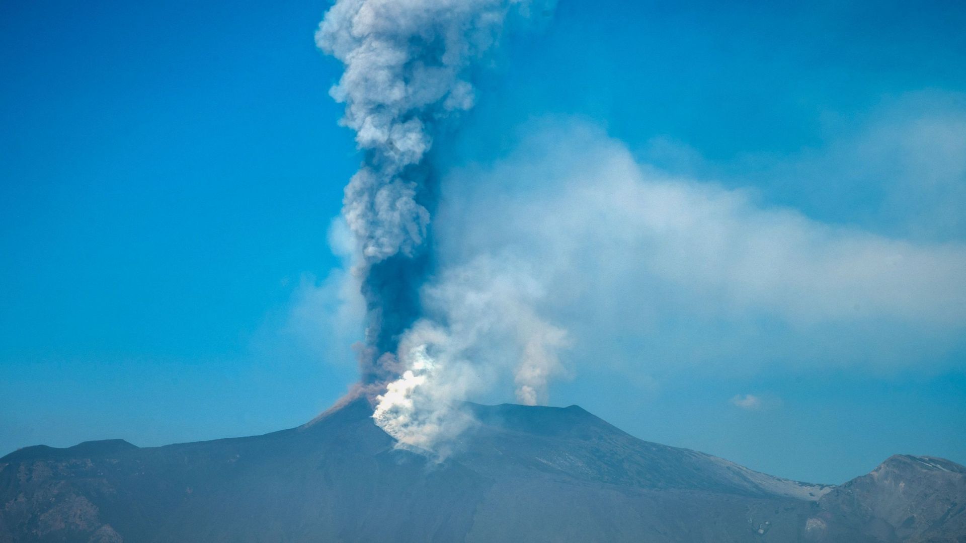 Une vue générale prise le 04 mars 2021 depuis Giarre, au nord de Catane, en Sicile, montre le volcan Etna crachant de la fumée..