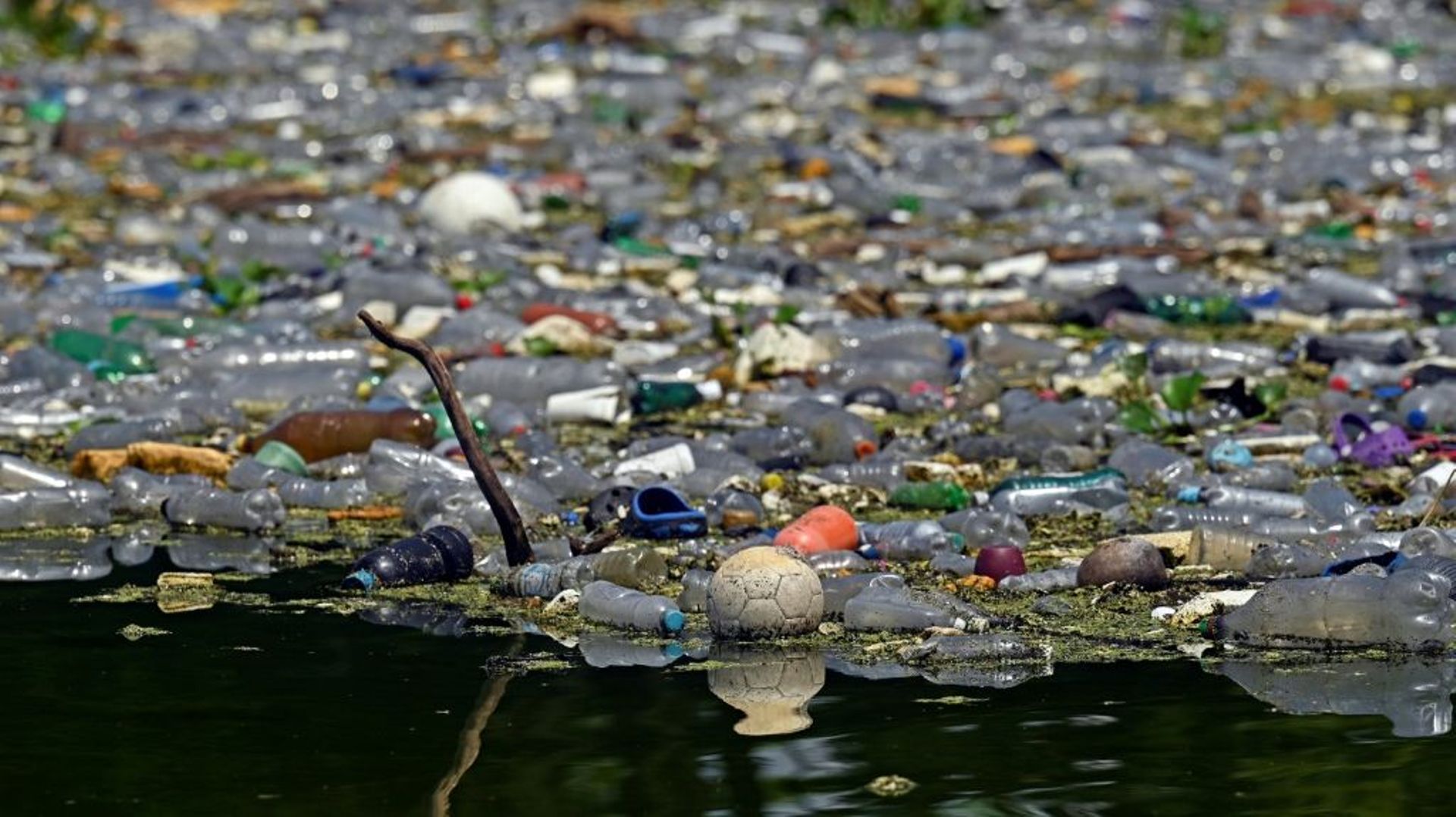 Des déchets plastiques et autres flottent à la surface du réservoir de Cerron Grande à Potonico, le 9 septembre 2022 au Salvador