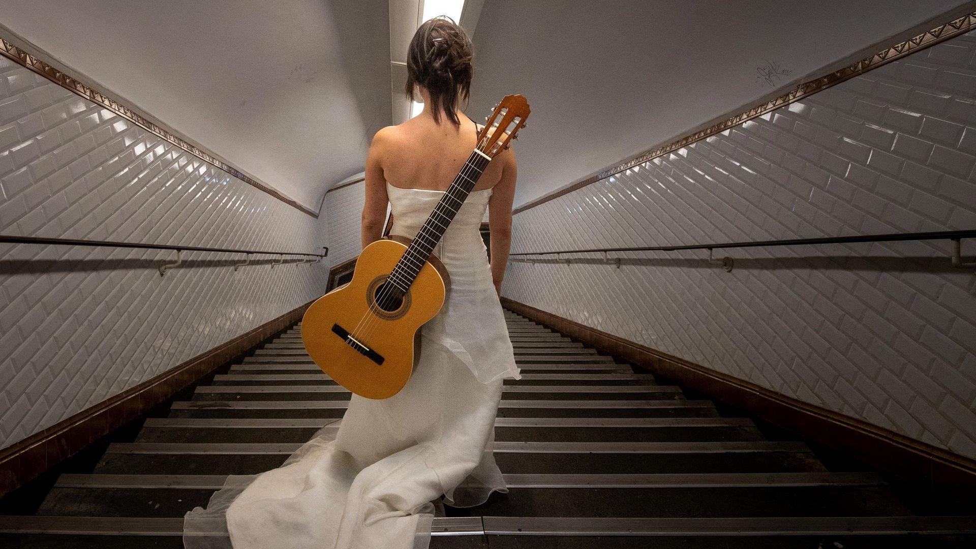 Eli Jadelot chante ses propres textes – des histoires de vie quotidienne racontées drôlement – vêtue d’une robe de mariée.