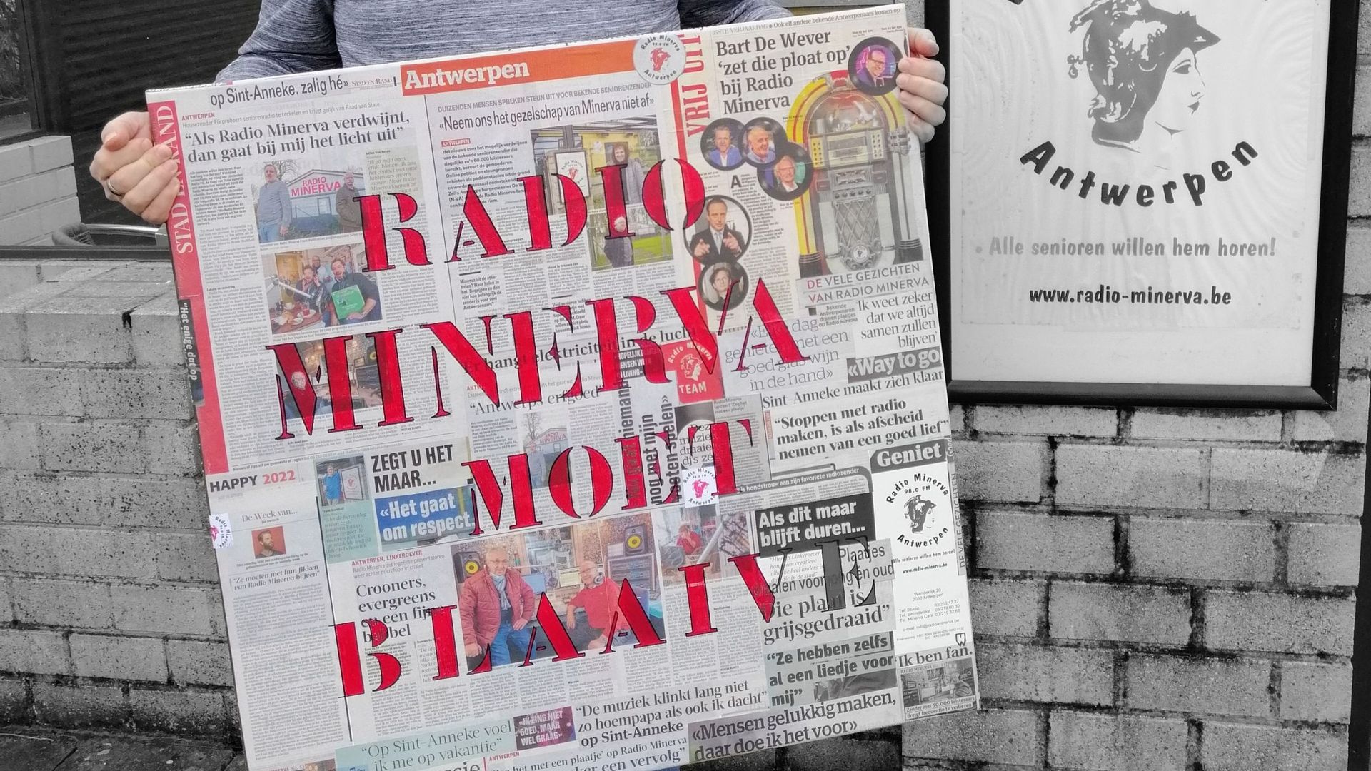 "Radio Minerva doit rester". Frank Boekhoff, président de la radio anversoise tient une affiche de soutien réalisée par un auditeur.