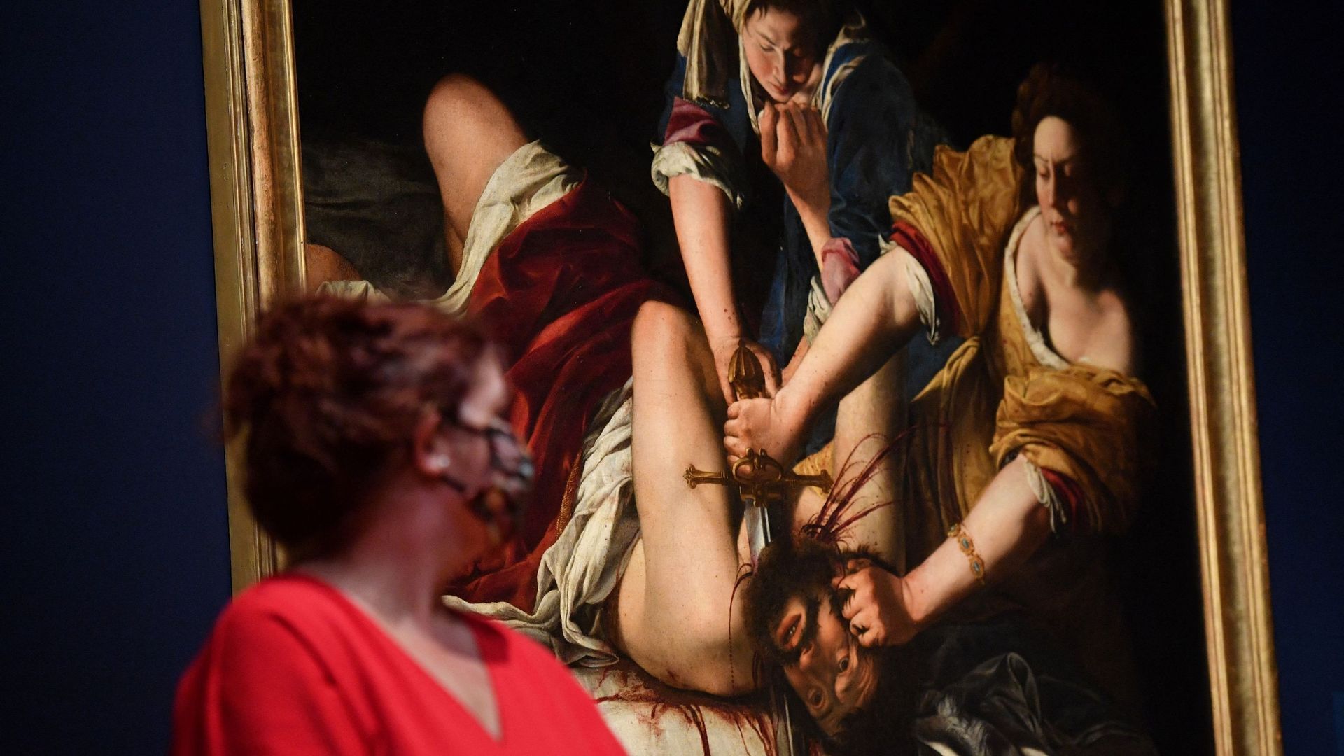 Une assistante de galerie pose devant une peinture intitulée "Judith décapitant Holopherne" de l’artiste baroque italienne Artemisia Gentileschi.