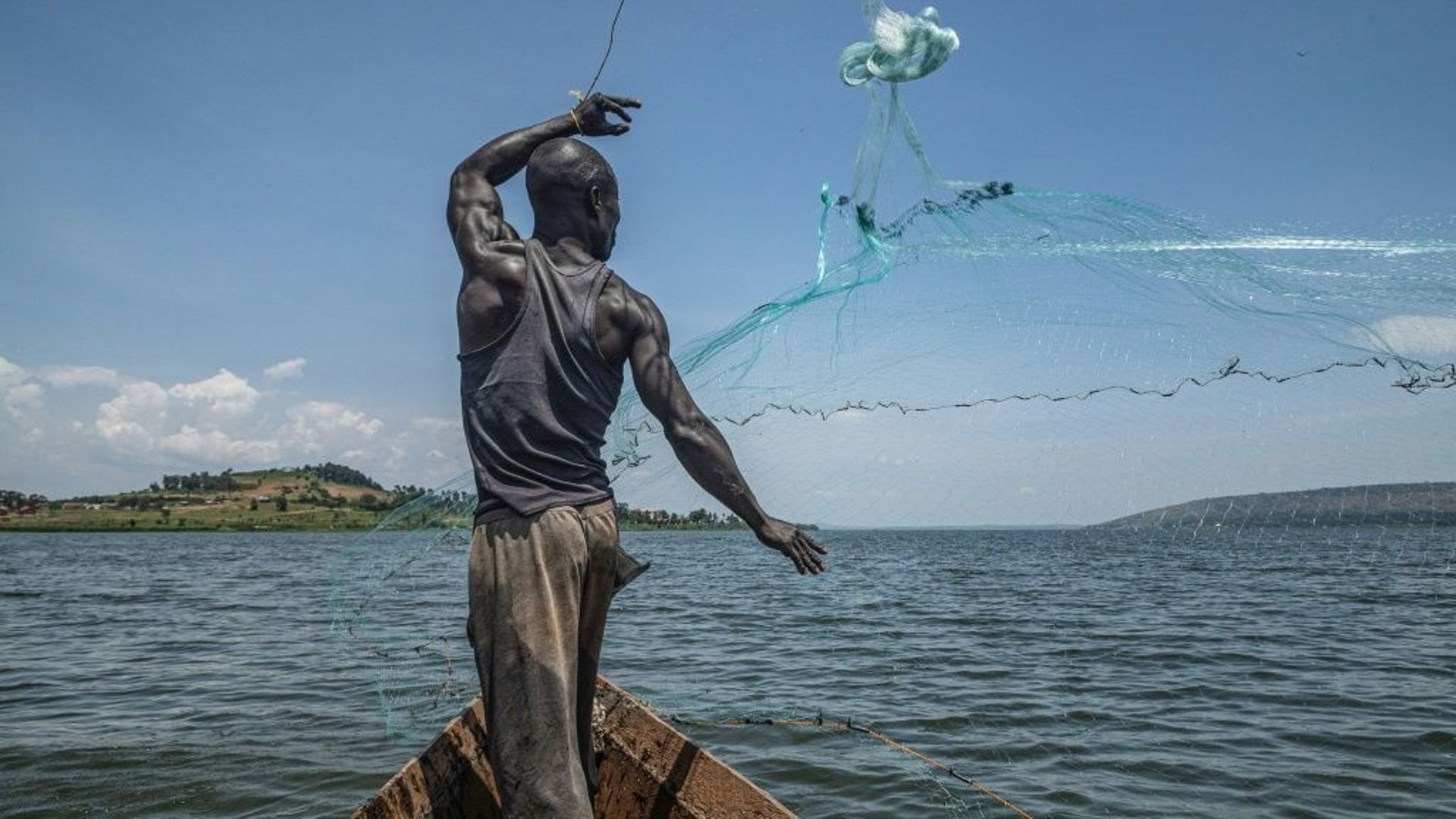 Jowali Kitagenda, 40 ans, jette son filet pour attraper des poissons sur le Nil à Jinja, dans le sud de l'Ouganda le 7 octobre 2022.