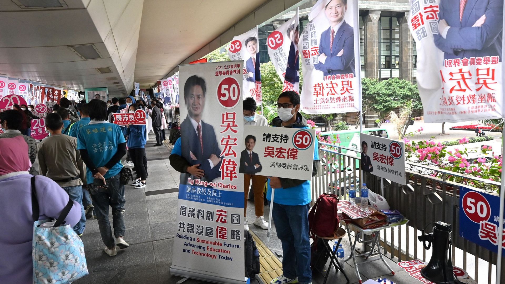 Un homme fait campagne pour un candidat aux élections du Conseil législatif dans le district de Wanchai à Hong Kong, le 19 décembre 2021.