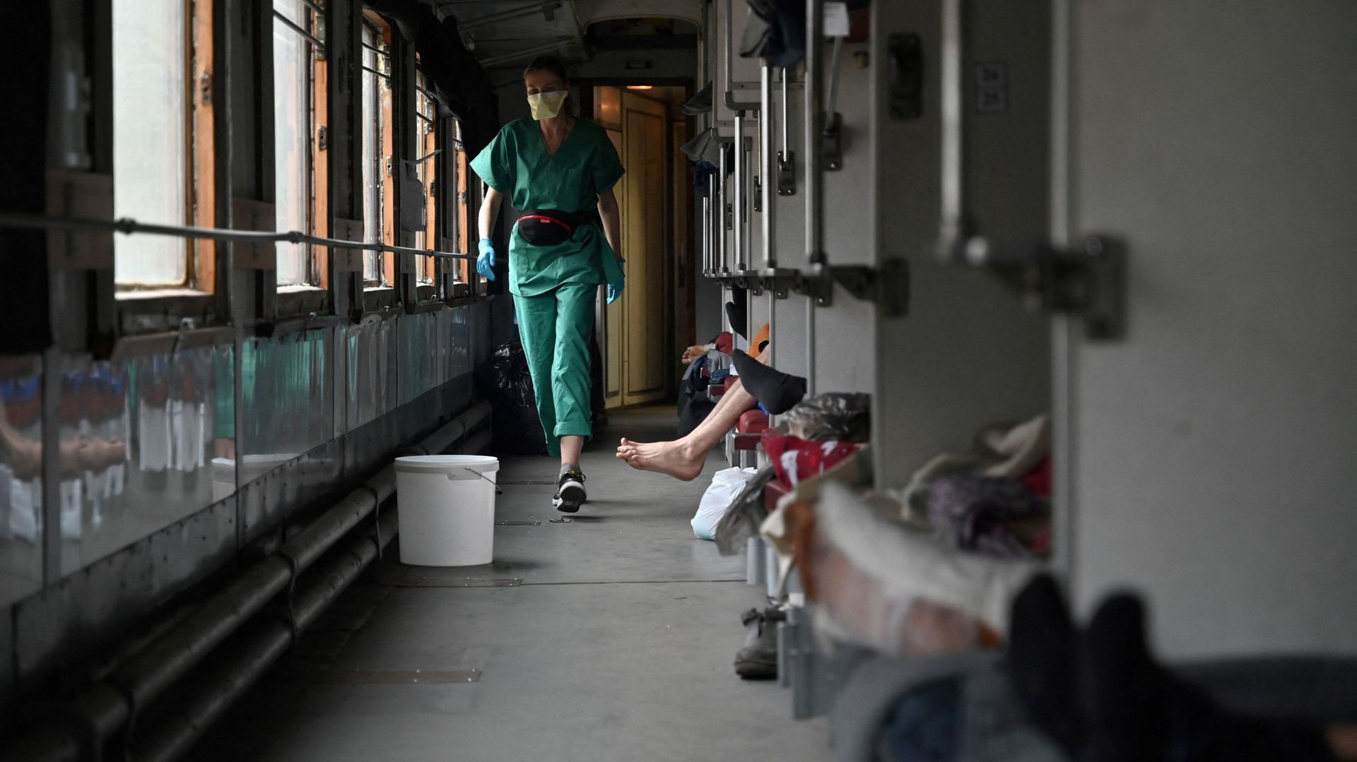 Une membre de l'équipe MSF soigne des patients dans un train d'évacuation médicale en route pour la ville de Lviv, dans l'ouest de l'Ukraine, le 10 avril 2022.