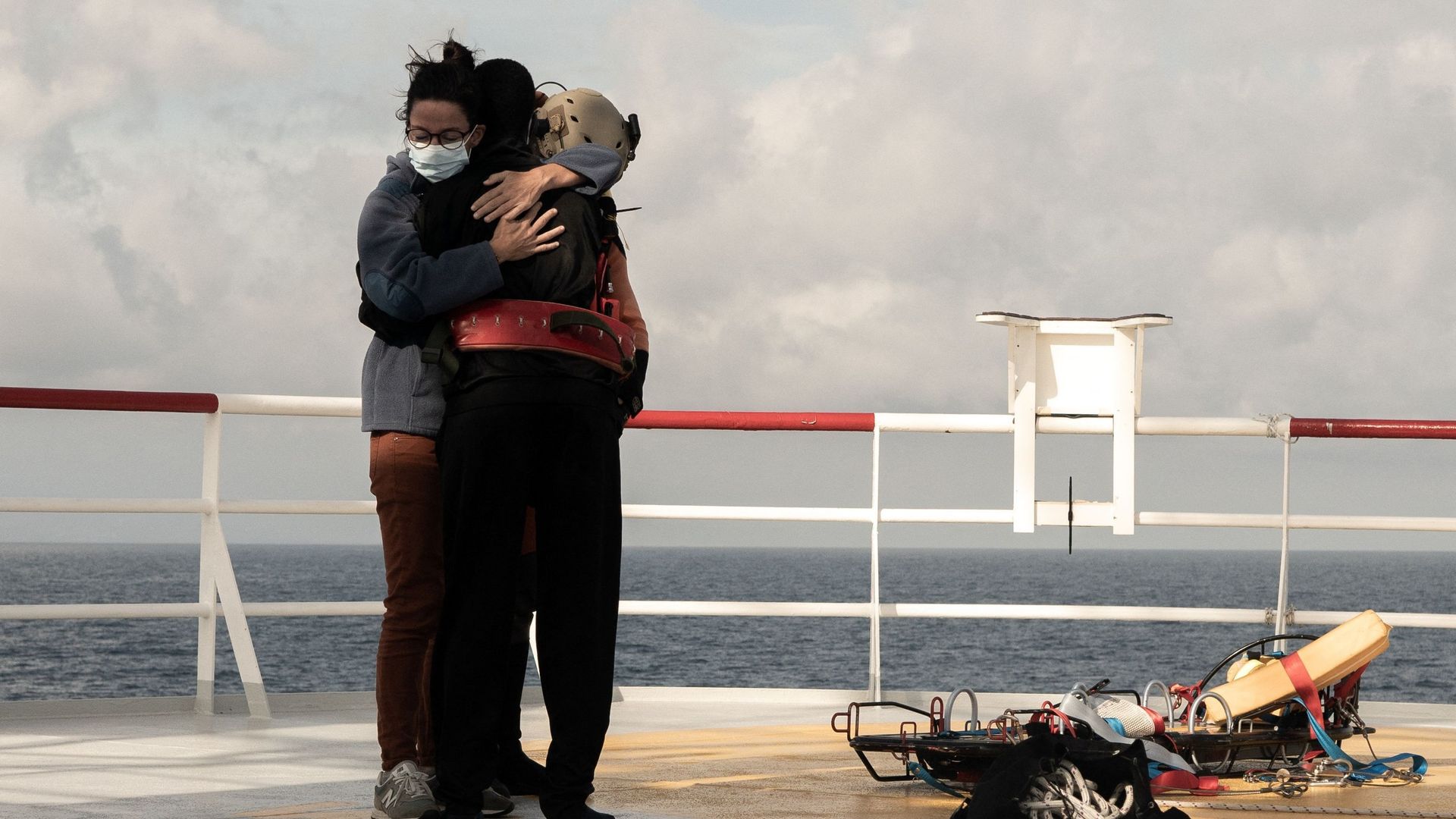 Un migrant et un volontaire s'embrassent alors que le migrant est sur le point d'être treuillé vers un hélicoptère de l'armée française depuis le navire de sauvetage Ocean Viking, le 10 novembre 2022, dans la mer Tyrrhénienne entre l'Italie et l'île de Co
