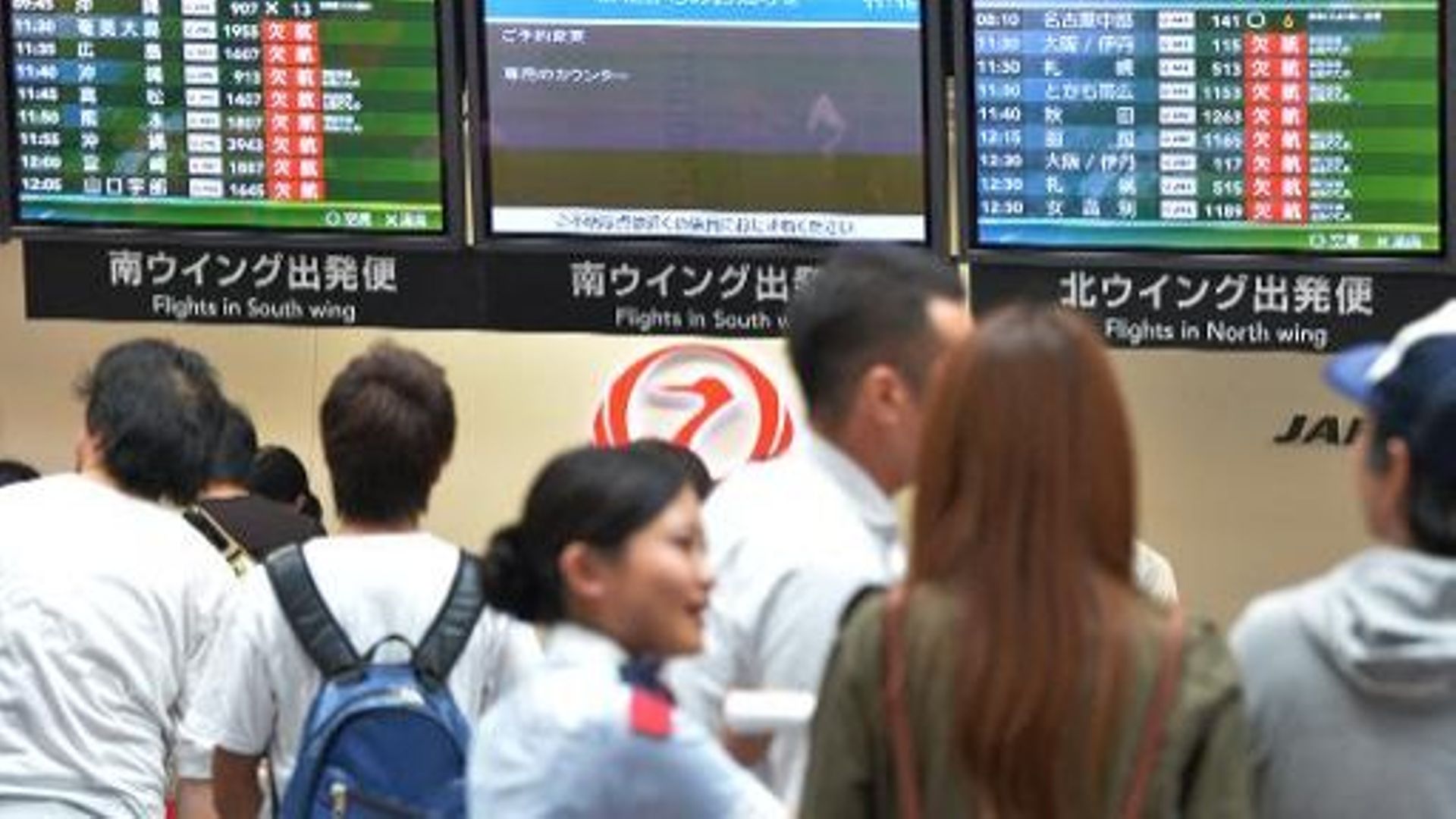 Des voyageurs attendent des informations sur l'annulation des vols en raison d'un typhon, le 16 septembre 2013 à l'aéroport de Tokyo 
