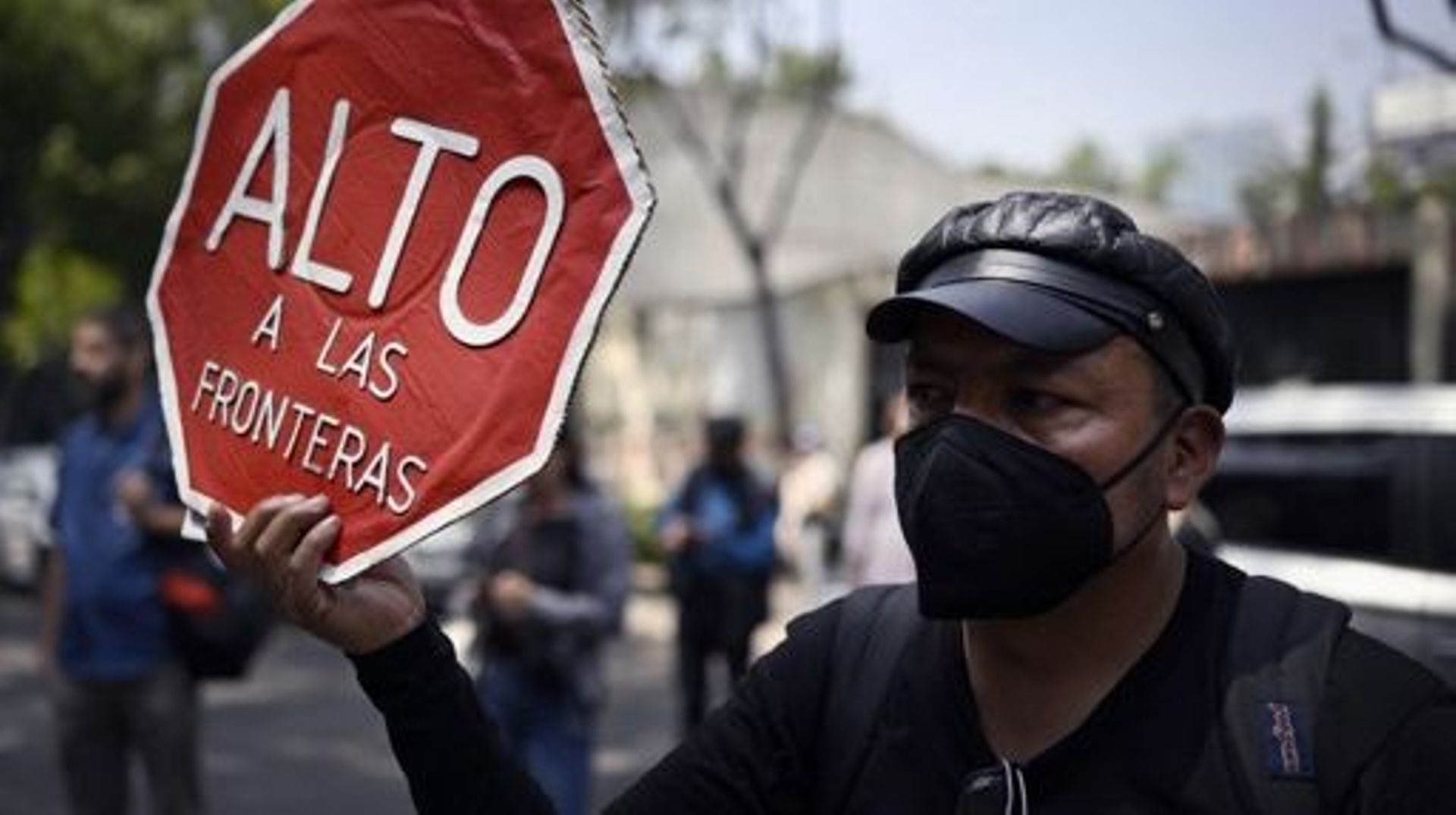 An activist with a sign reading "Stop the borders" protests in support of migrants outside the Mexican Interior Ministry in Mexico City on March 29, 2023. Mexico's president vowed Wednesday there would be "no impunity" for those found responsible for the 