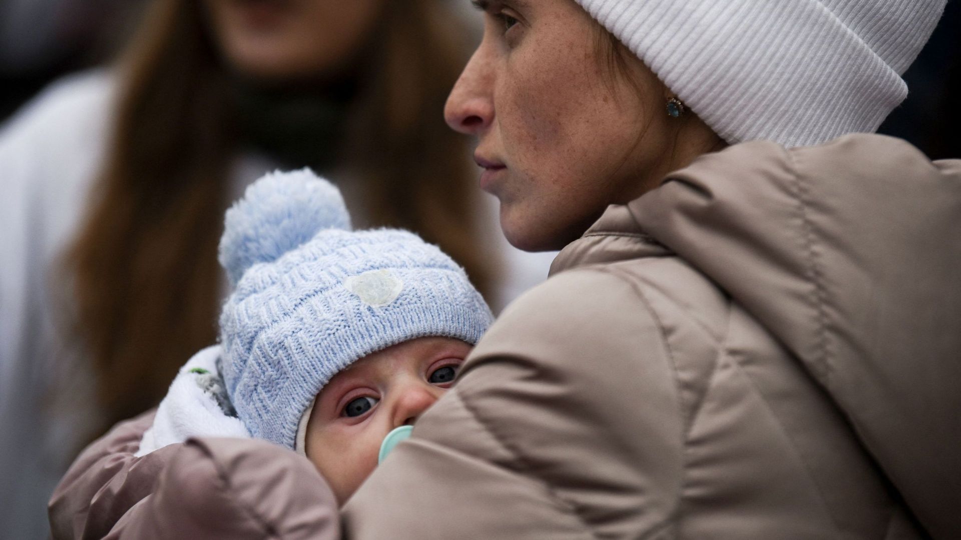 Une évacuée ukrainienne, Luda Oksonenko, tient son bébé de deux mois après avoir franchi la frontière ukraino-roumaine à Siret, dans le nord de la Roumanie, le 16 mars 2022. -