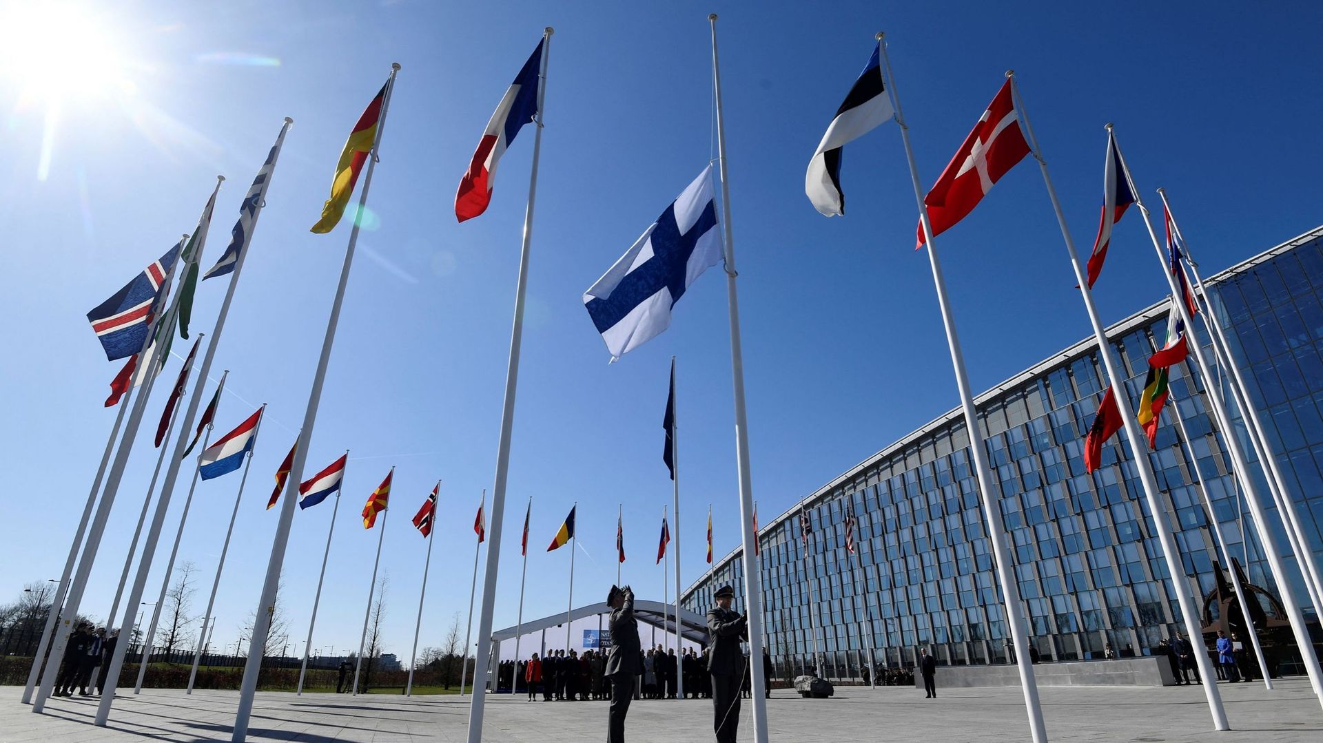 Des militaires finlandais installent le drapeau national finlandais au siège de l'OTAN à Bruxelles, le 4 avril 2023.