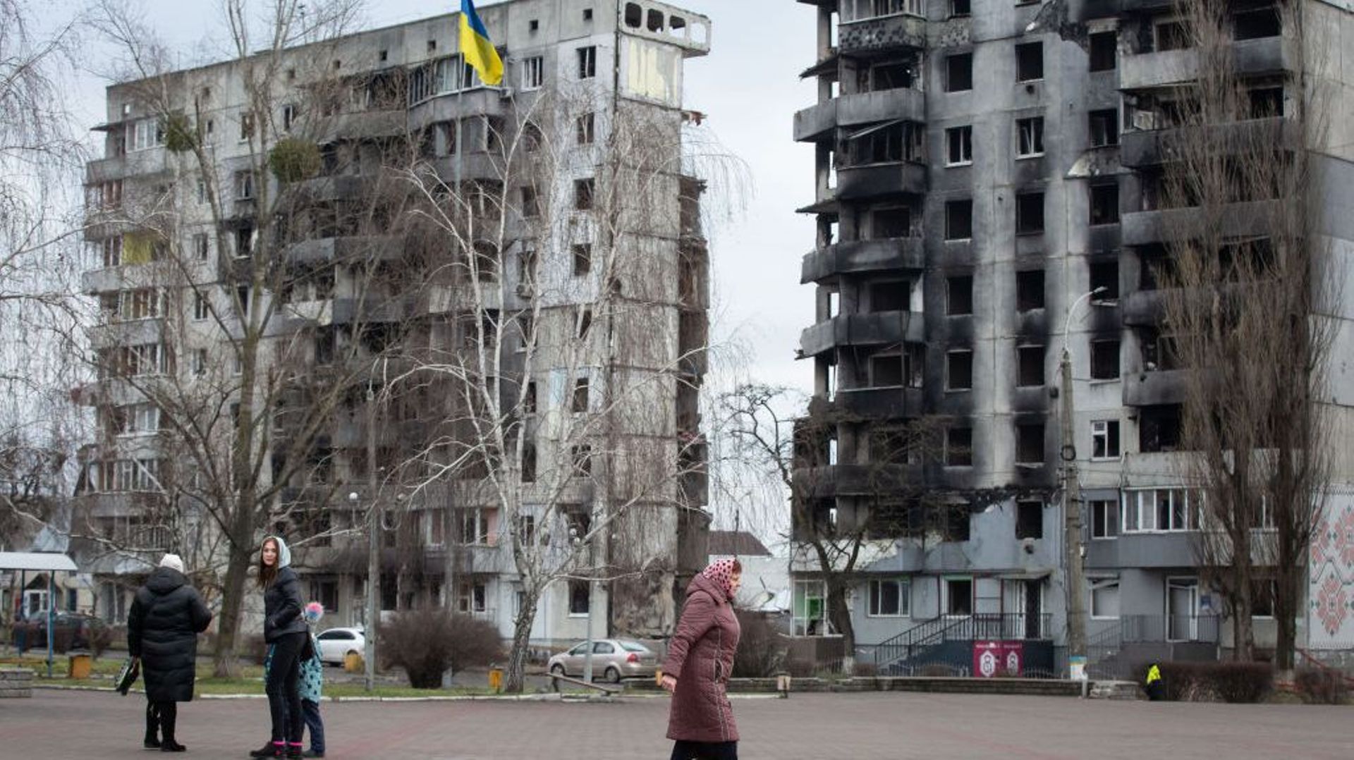 Une femme marche près d'un immeuble résidentiel détruit dans la ville de Borodyanka, région de Kiev, le 3 janvier 2023.