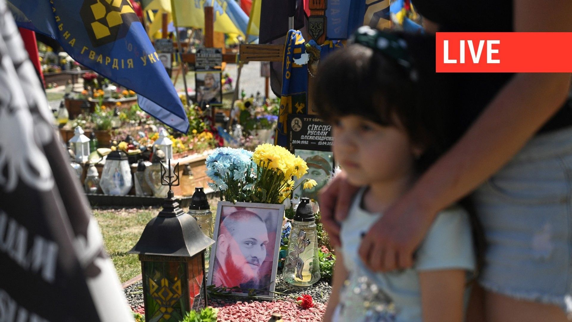 Dzvinka, la fille de 5 ans de Ruslan Siksoy, soldat ukrainien mort au combat, près de sa tombe au cimetière de Lychakiv à Lviv, le 1er juin 2023.