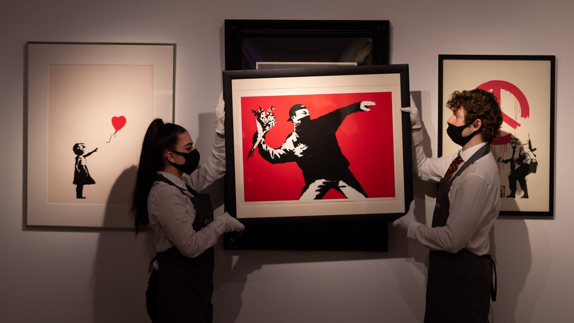 L’œuvre "Love is in the Air de Banksy" est exposée pendant les préparatifs de la vente en ligne à la maison de vente aux enchères Christies, le 26 mars 2021 à Londres, en Angleterre. La vente comprend "The Prints & Multiples" et "Banksy : I Can’t Believe 