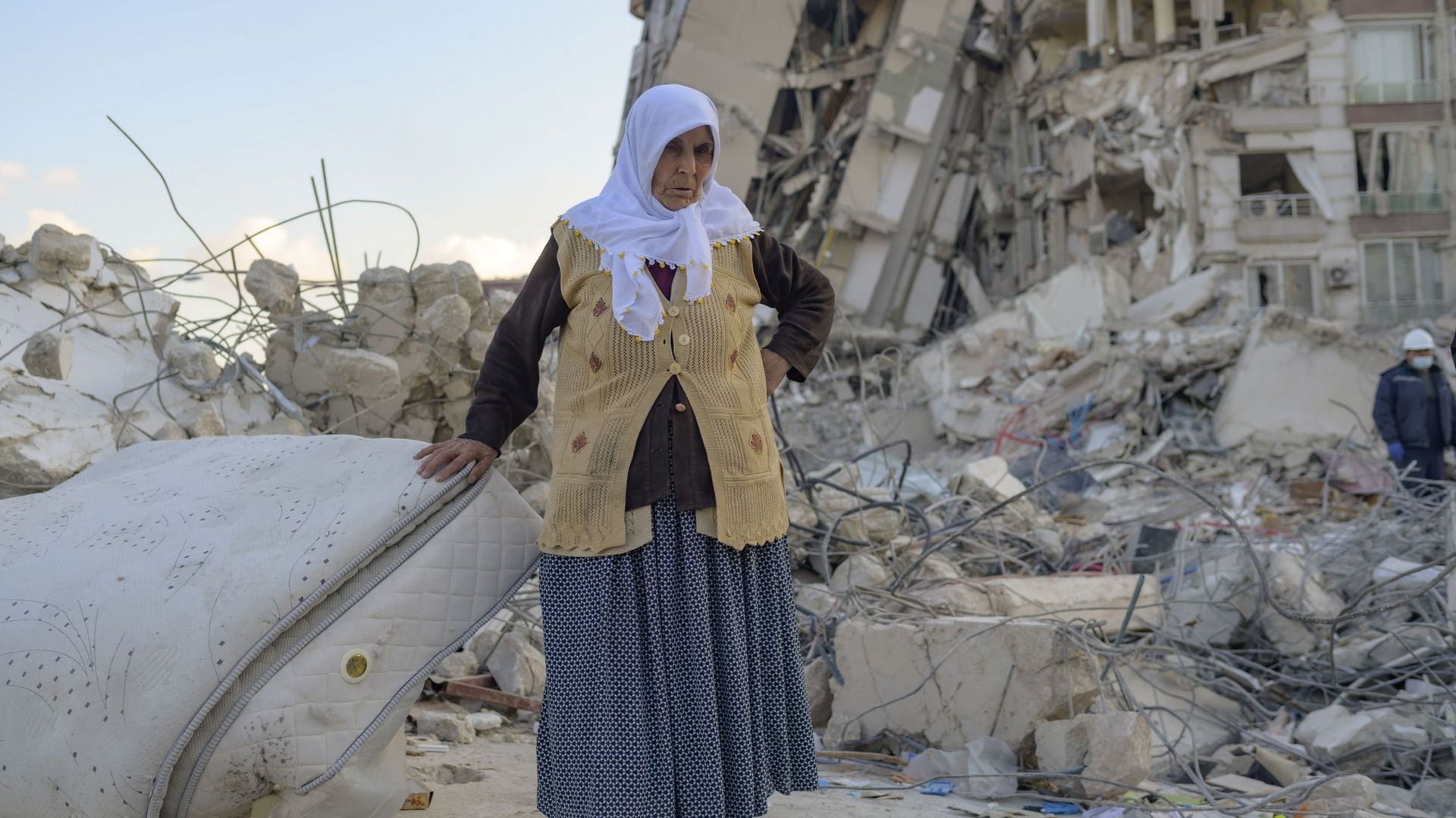 Une femme attend que ses proches soient retirés de sous les décombres d'un bâtiment effondré à Hatay, le long de la côte méditerranéenne, dans le sud de la Turquie, le 19 février 2023.