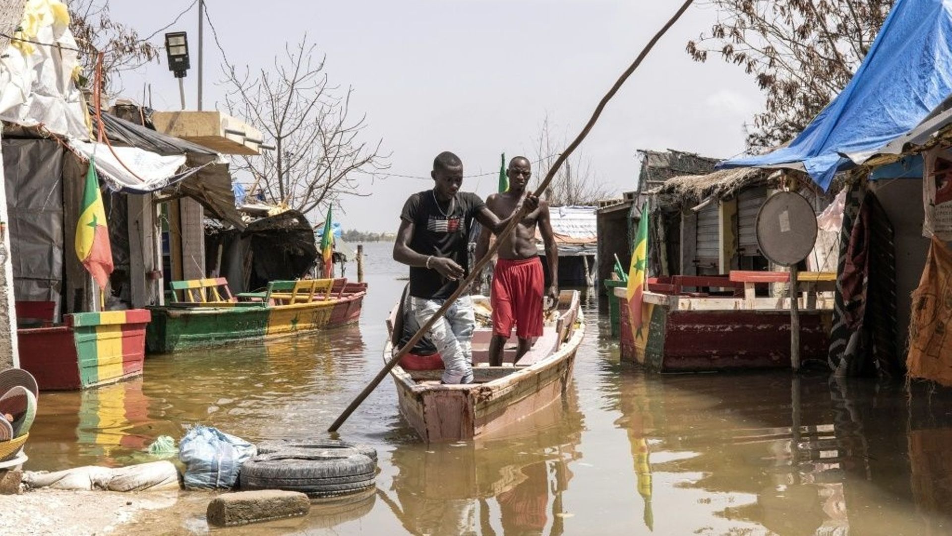 Des résidents à pirogue dans un marché inondé des abords du lac Rose, à Niaga le 19 octobre 2022.