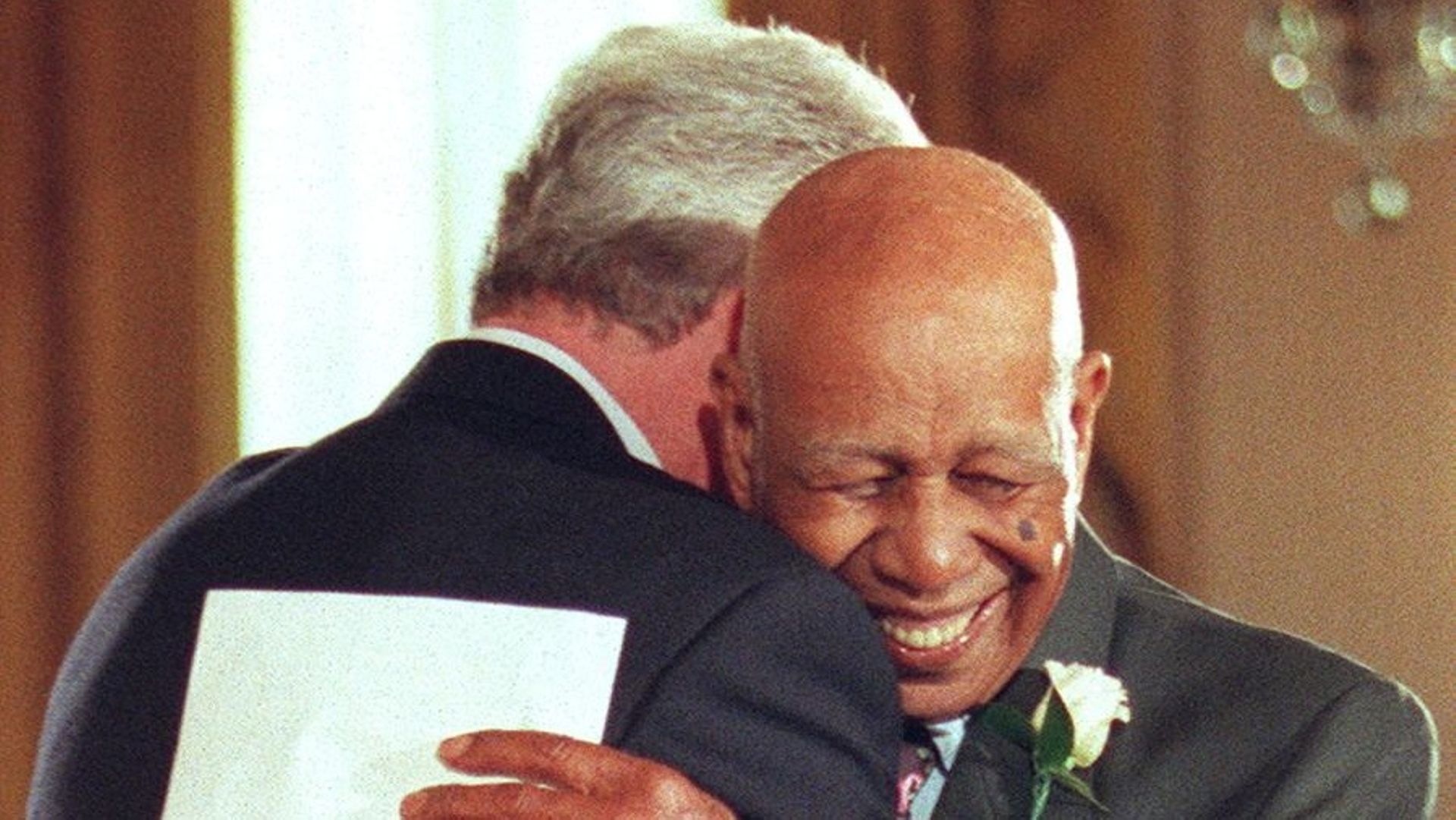 Herman Shaw, âgé de 94 ans, embrasse le président américain Bill Clinton après avoir reçu des excuses publiques pour avoir été victime de l’étude Tuskegee sur la syphilis, lors d’une cérémonie à la Maison Blanche, à Washington, le 16 mai 1997.