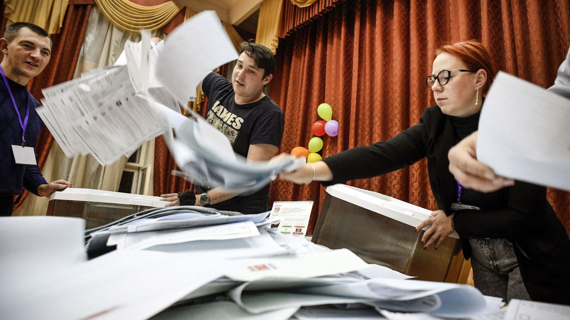 Les membres d'une commission électorale vident une urne dans un bureau de vote à Moscou, le 19 septembre 2021