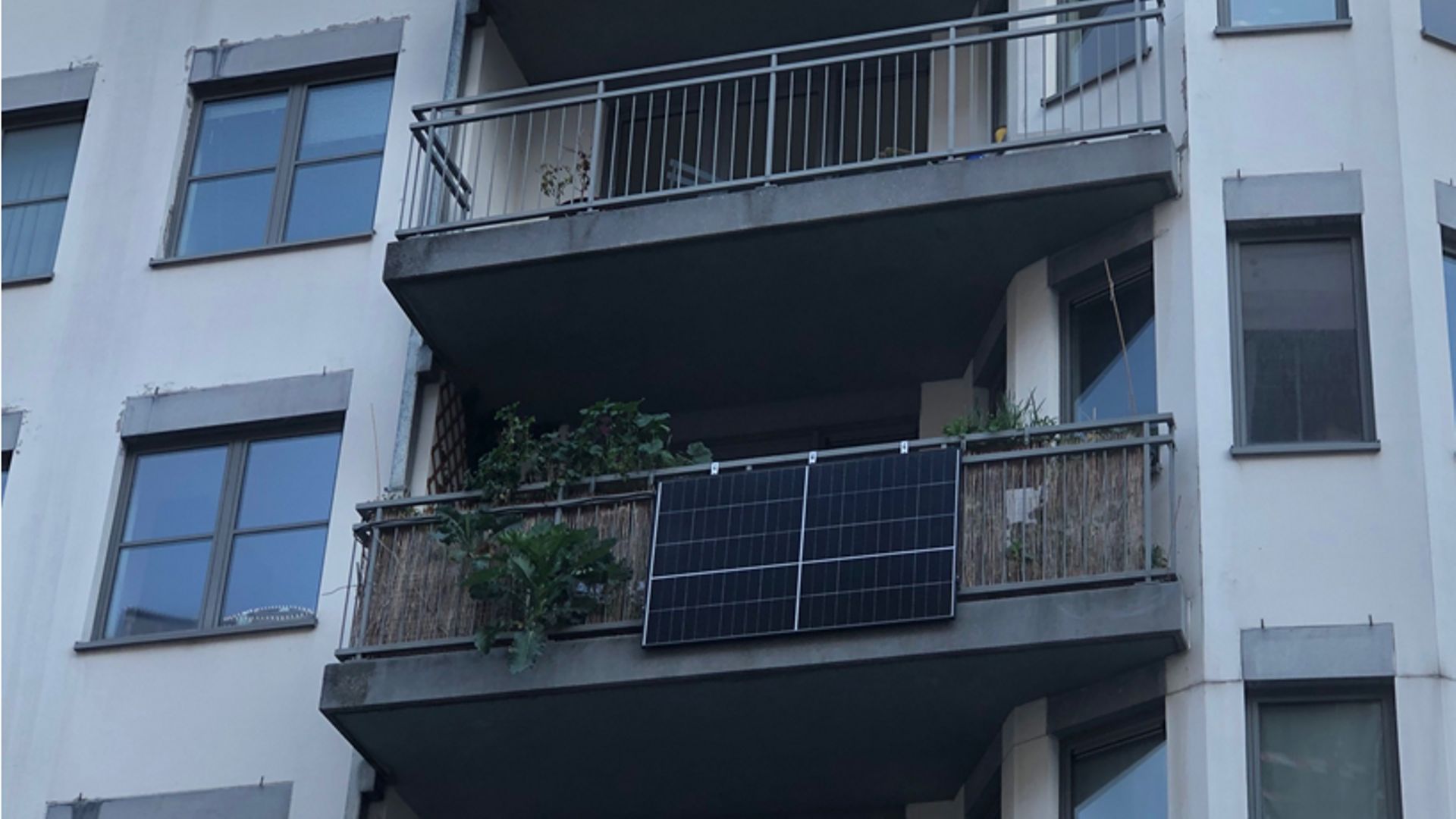 Un residente di Bruxelles installa un pannello solare sulla sua veranda