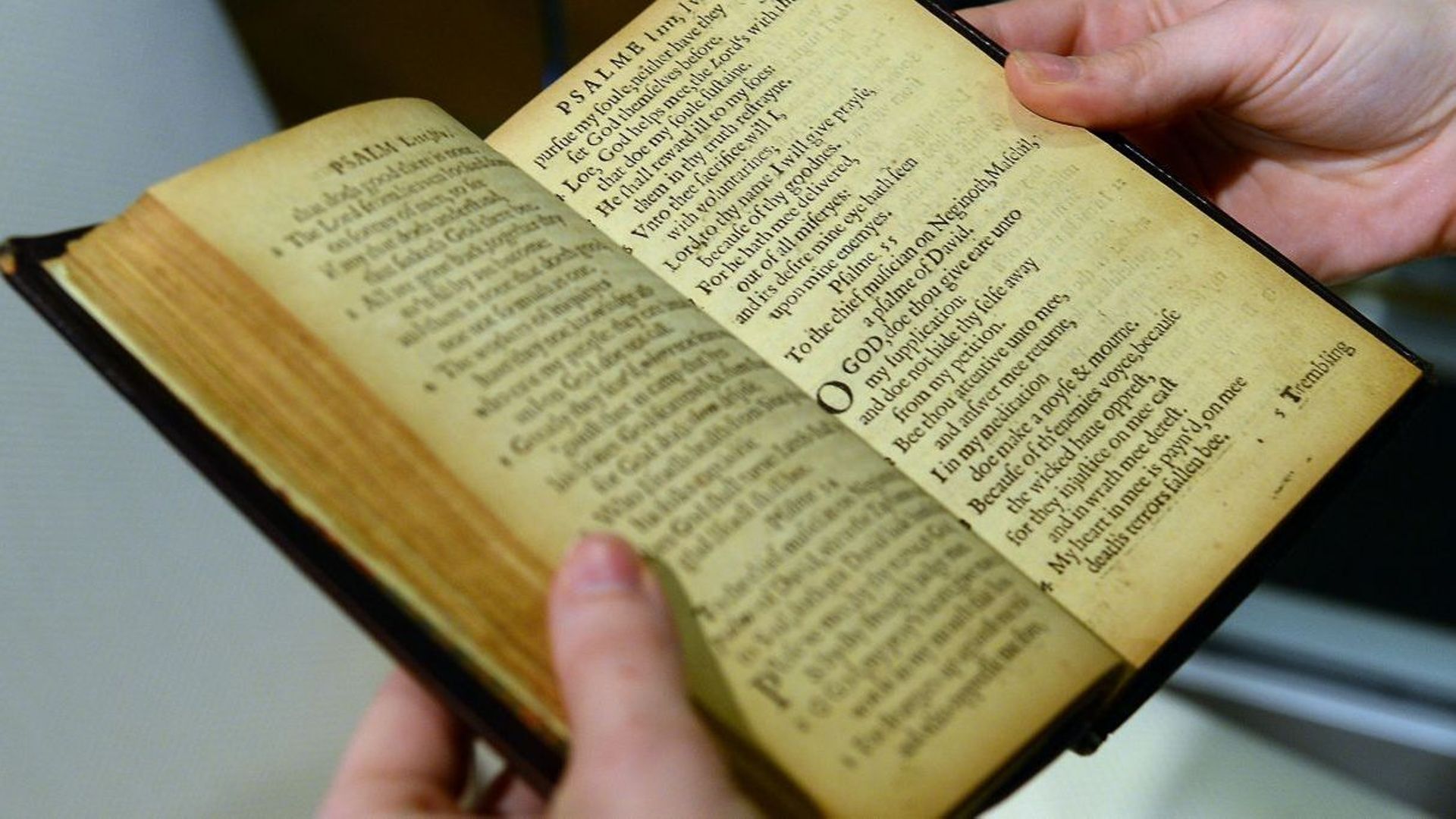 Un employé de Sotheby tient une copie du “Bay Psalm Book”, datant de 1640, le premier livre imprimé sur ce qui allait devenir le territoire américain