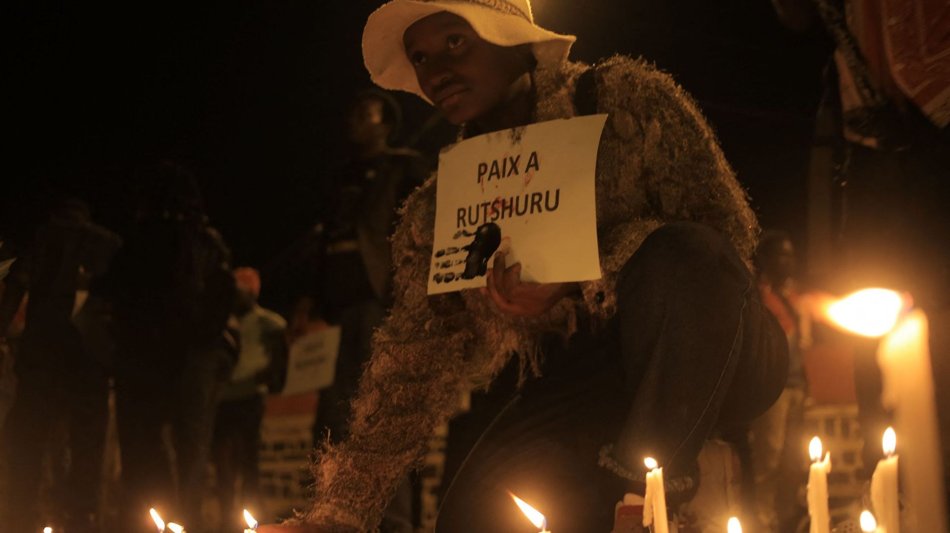 Une femme place une bougie à Beni le 7 décembre 2022 lors d’une veillée de prière en mémoire des victimes des troubles en cours dans l’est du pays. Au moins 131 civils ont été tués par les rebelles du M23 les 29 et 30 novembre dans l’est de la République 