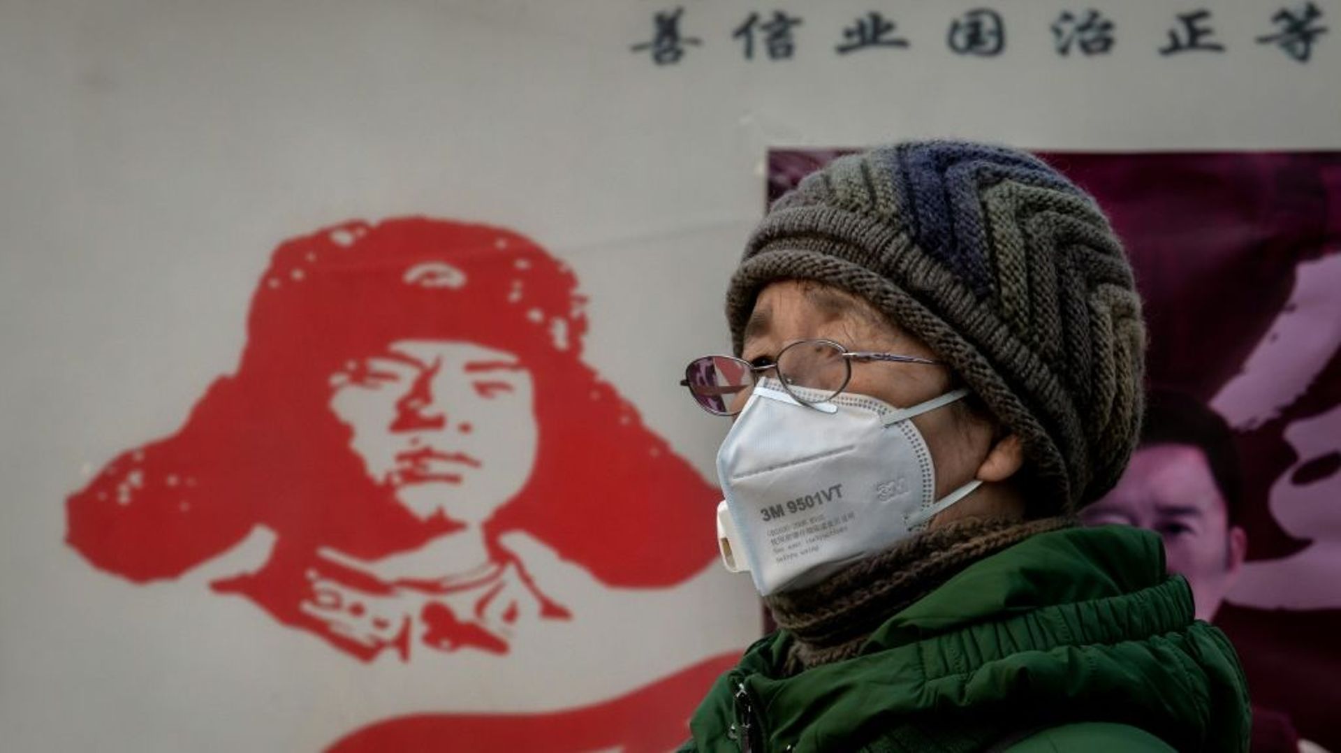 Une femme porte un masque de protection contre l'épidémie de coronavirus, près de la gare de Pékin, le 27 janvier 2020
