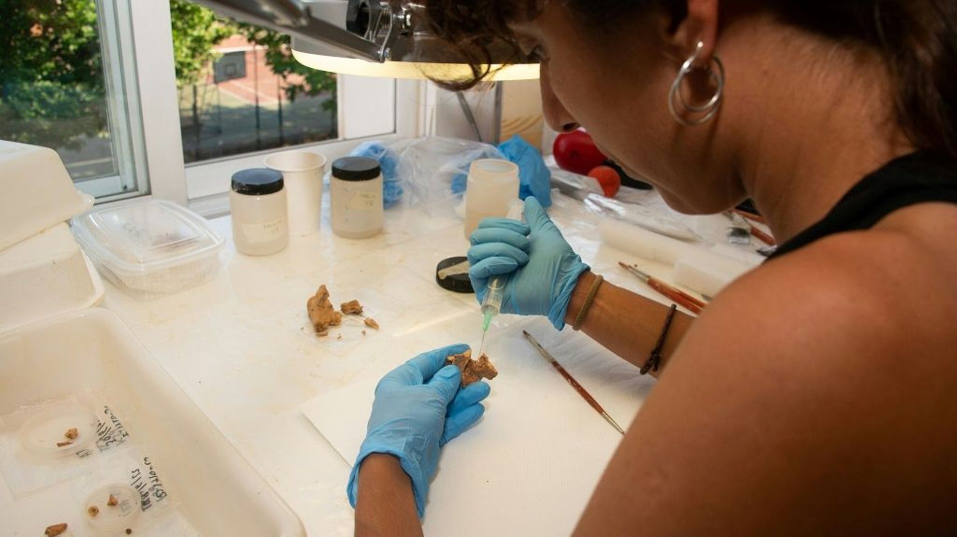 Photo non datée publiée par l’équipe de recherche d’Atapuerca le 8 juillet 2022 montrant une des chercheuses, Elena Moreno, manipulant un fragment d’os du visage d’un hominidé dans un laboratoire à Burgos, en Espagne