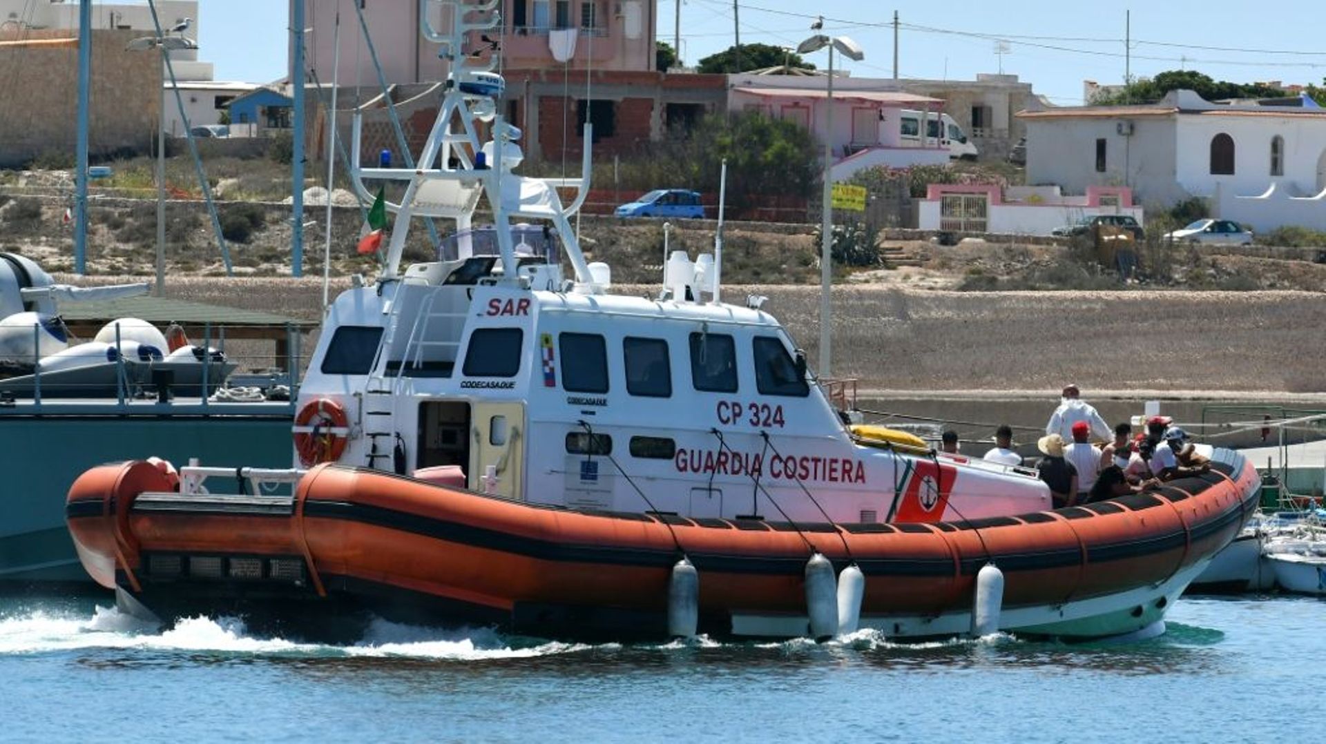 Arrivée de migrants recueillis par des gardes-cotes italiens en Méditerranée, au port de l'île de Lampedusa, le 30 juillet 2020
