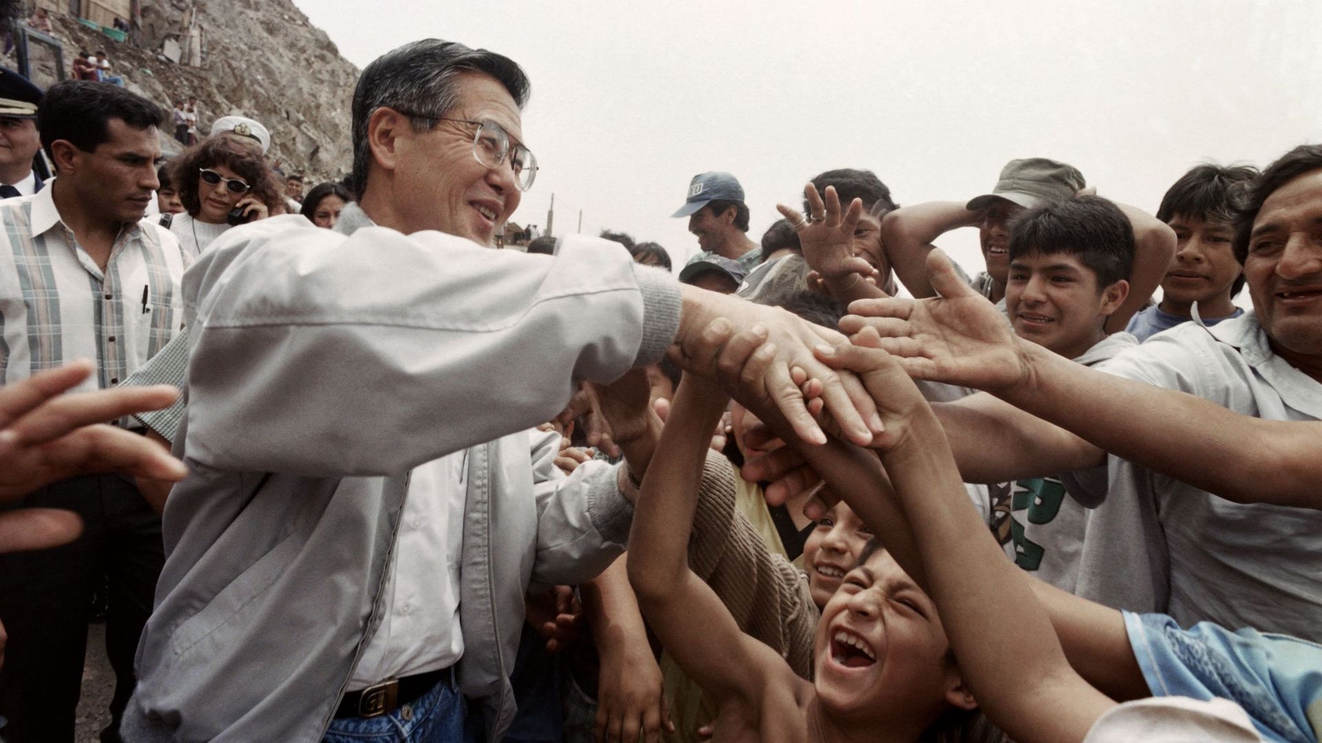 Le président péruvien Alberto Fujimori serre la main des habitants d'un bidonville de Lima, le 7 janvier 1997.