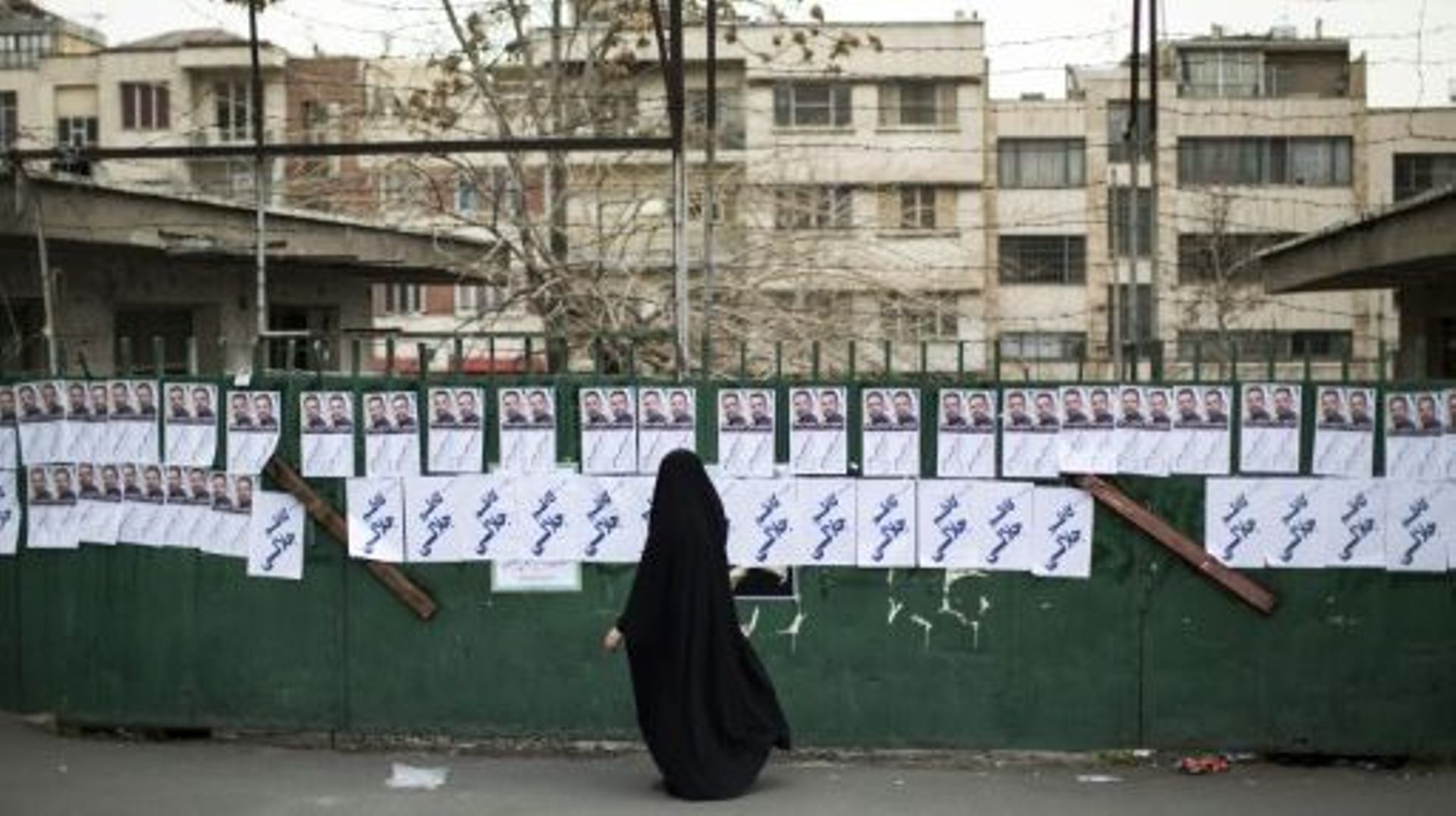 Une femme passe devant des panneaux électoraux, le 20 février 2016 à Téhéran
