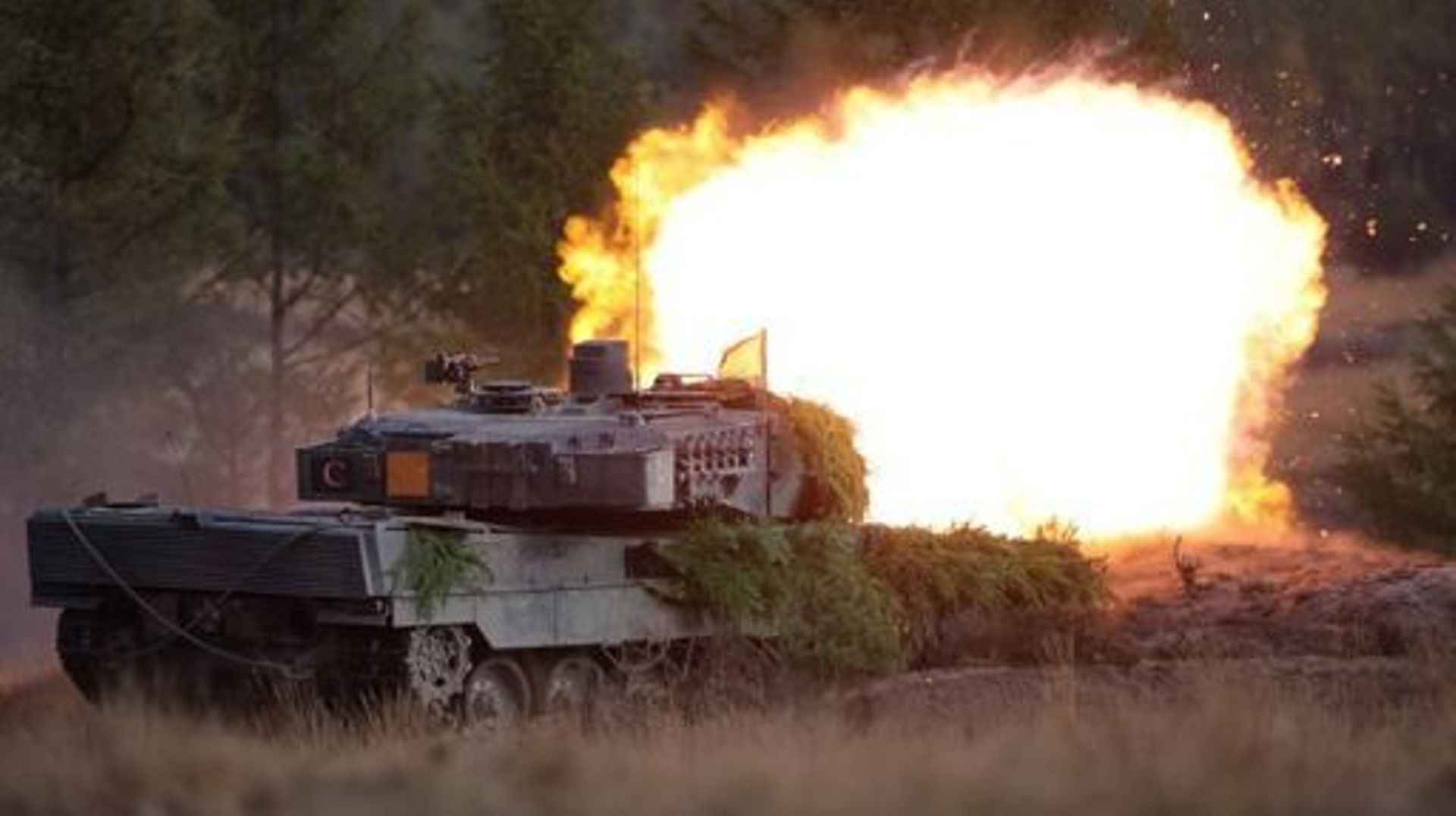 A Leopard 2 main battle tank of the German armed forces Bundeswehr shoots during a visit by the German Chancellor of  the troops during a training exercise at the military ground in Ostenholz, northern Germany, on October 17, 2022. Germany on January 25, 