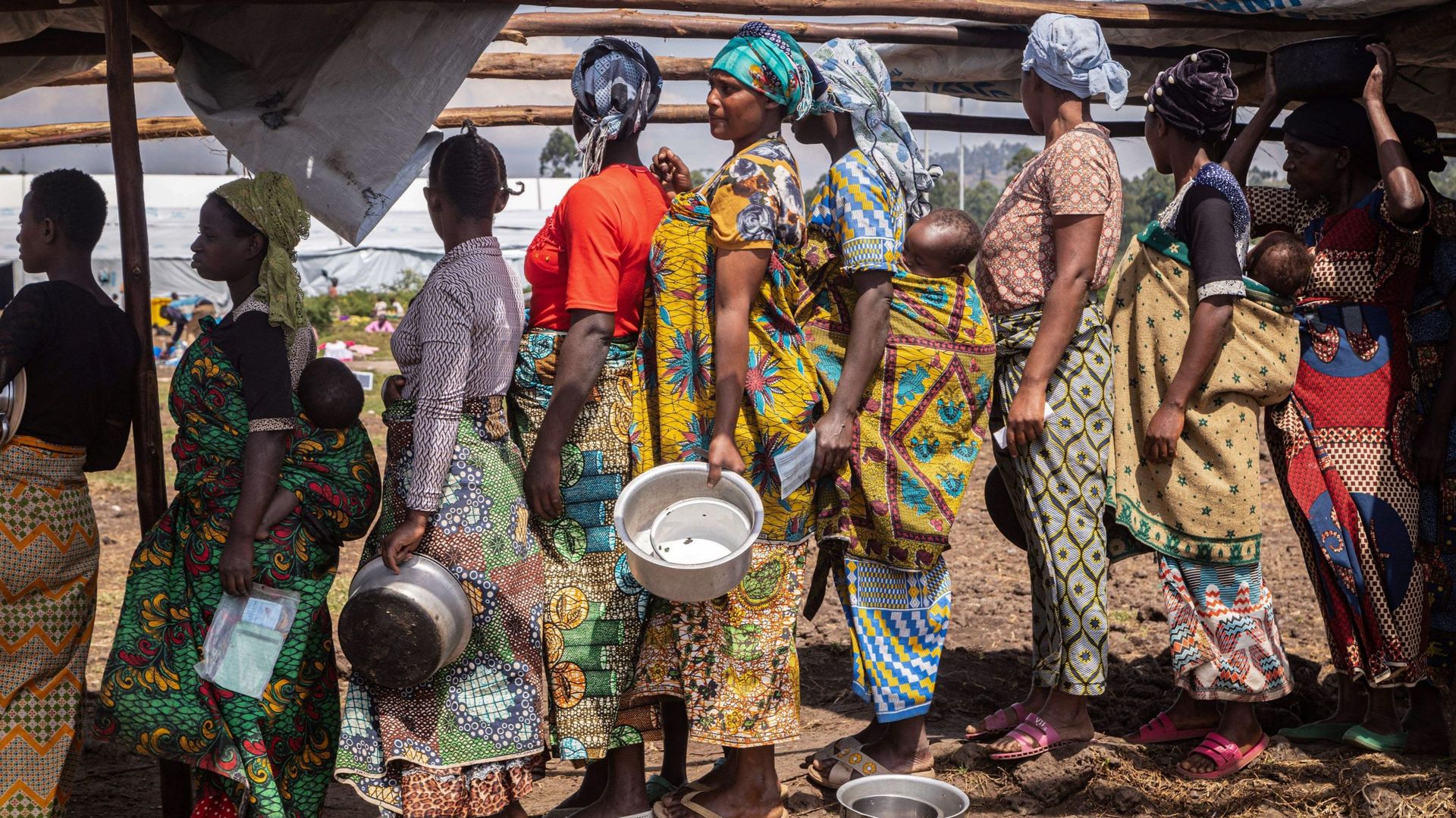 Des réfugiés de la République démocratique du Congo (RDC) font la queue pour déjeuner dans la zone d’attente de Nyakabande à Kisoro, en Ouganda, le 7 juin 2022, après des combats meurtriers entre les rebelles du M23, l’un des 120 groupes armés qui sévisse