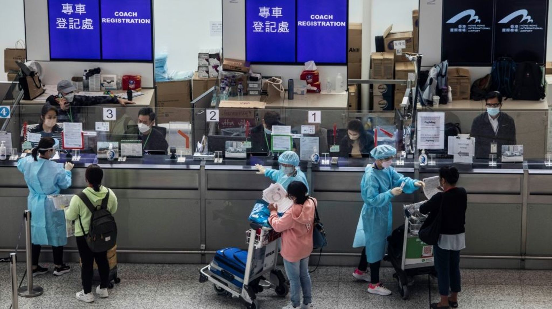 Des voyageurs se font enregistrer pour effectuer leur quarantaine dans un hôtel à leur arrivée à l’aéroport de Hong Kong, le 1er avril 2022