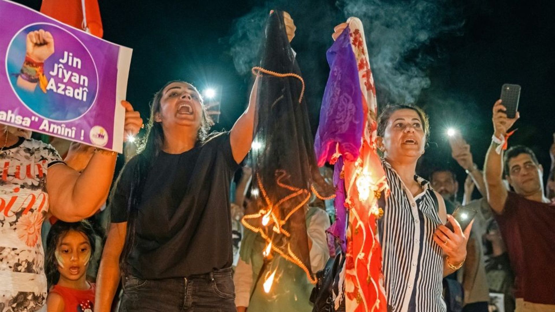 Des femmes brûlent des voiles en solidarité avec les manifestantes en Iran, lors d'un rassemblement à Limassol, le 1er octobre 2022 dans le sud de Chypre