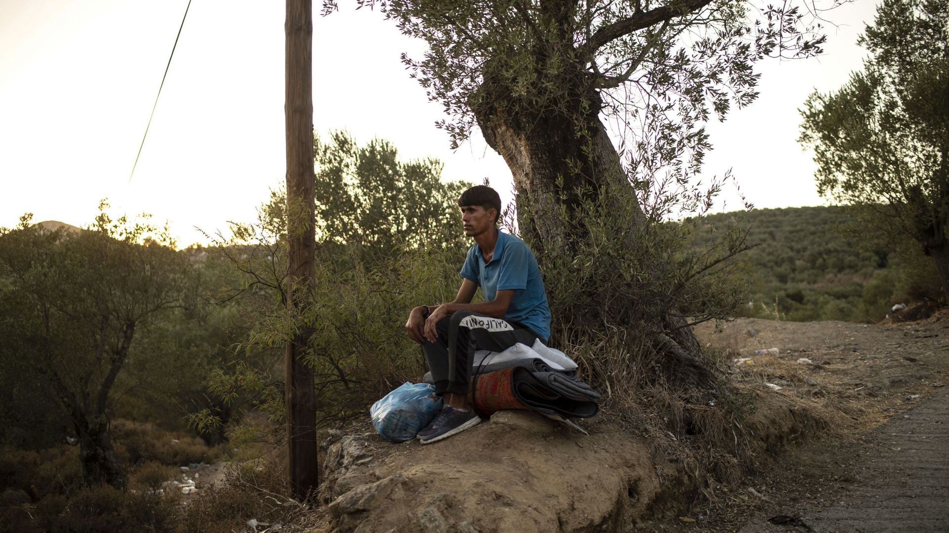 Migrant assis sur une souche d'arbre à Moria, sur l'île de Lesbos, ce 14 septembre 2020