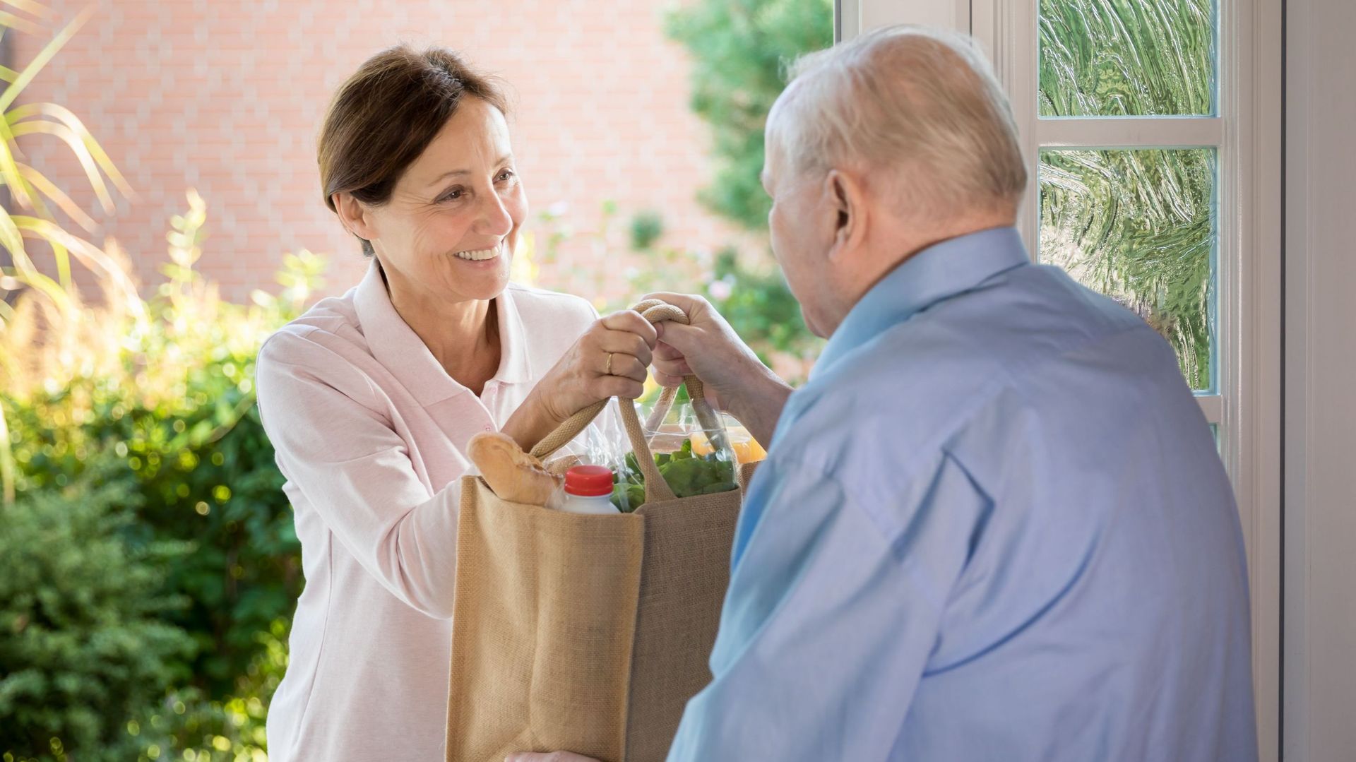 Home caregiver woman helping senior man