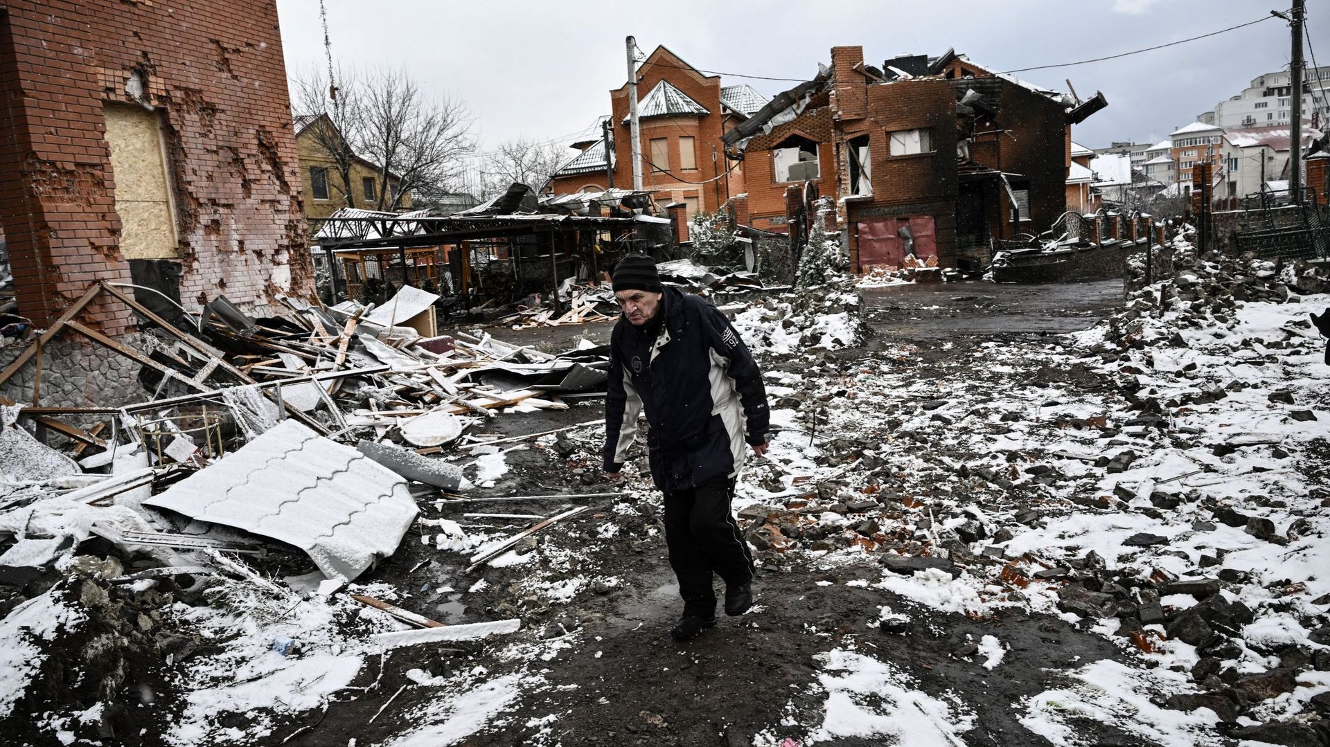 Un homme marche entre des maisons détruites lors de frappes aériennes sur la ville de Bila Tserkva, dans le centre de l'Ukraine, le 8 mars 2022.