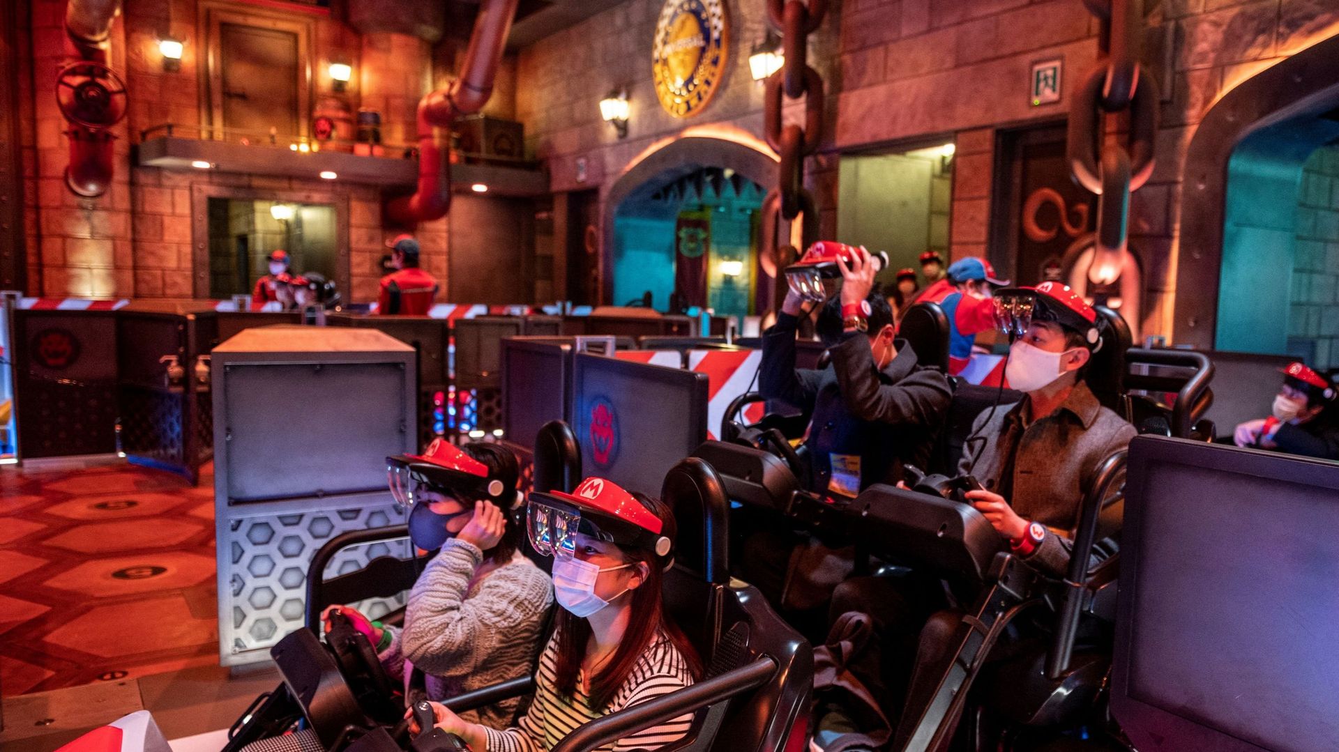 Des fans d’Universal Studios Japan portent des lunettes de réalité augmentée sur l’attraction "Mario Kart" lors de l’avant-première médiatique du Super Nintendo World à Universal Studios Japan d’Osaka.