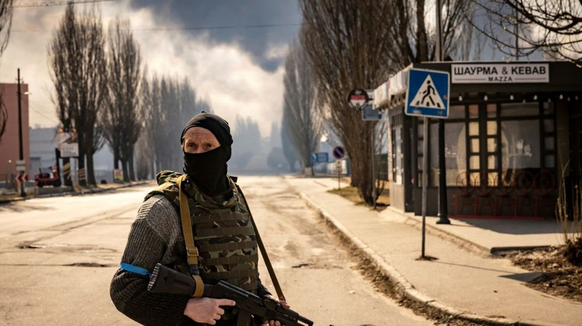 Un membre de forces ukrainiennes dans la banlieue de Kiev après des bombardements, le 24 mars 2022
