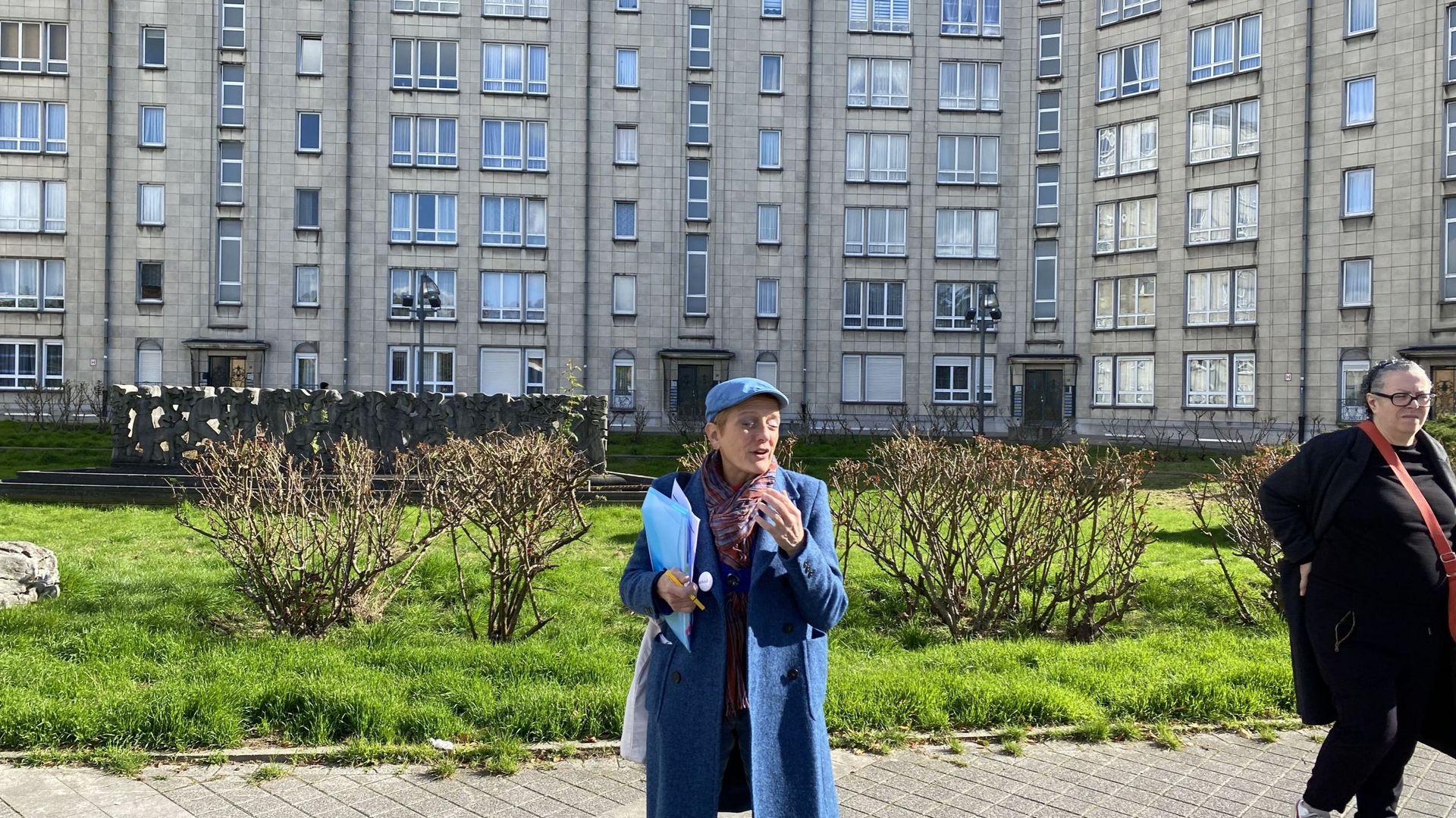 La guide du jour devant une tour de logements à Molenbeek