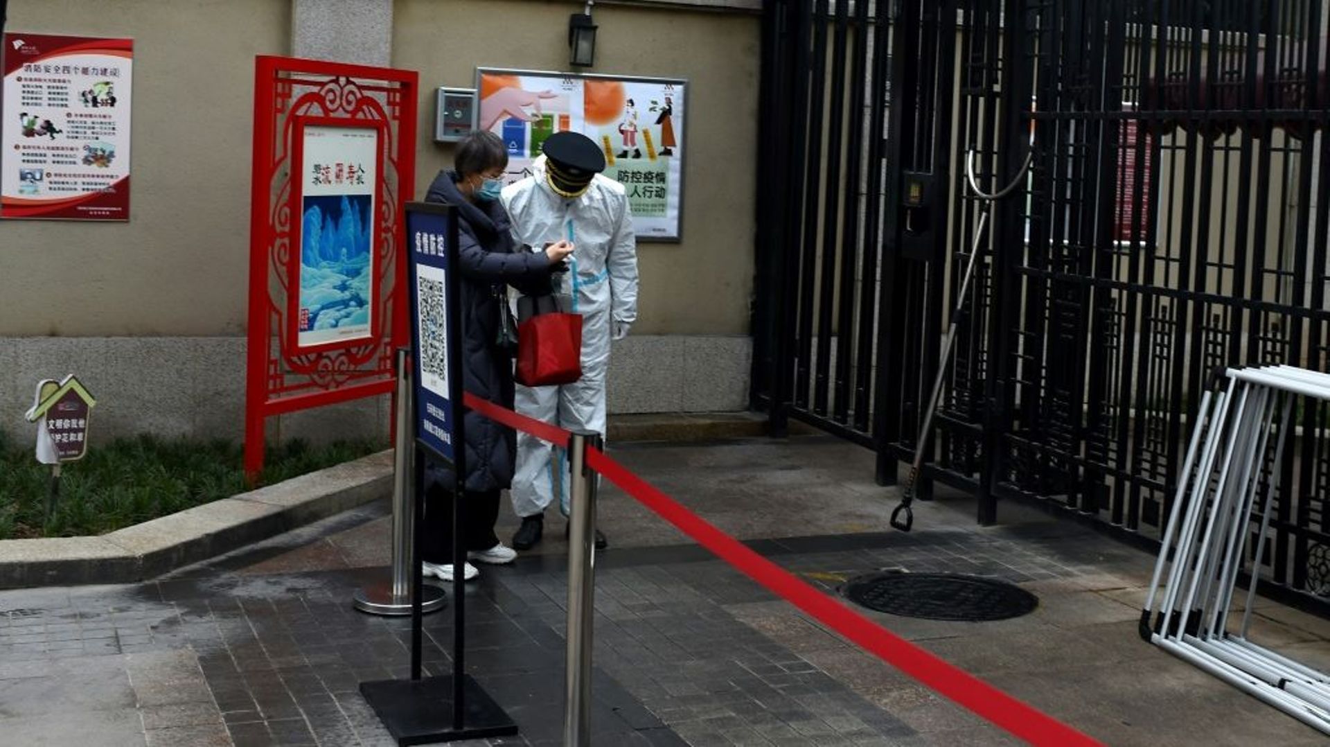 Un garde de sécurité vérifie les documents d'une habitante pendant un confinement à Xi'an, le 23 décembre 2021 en Chine