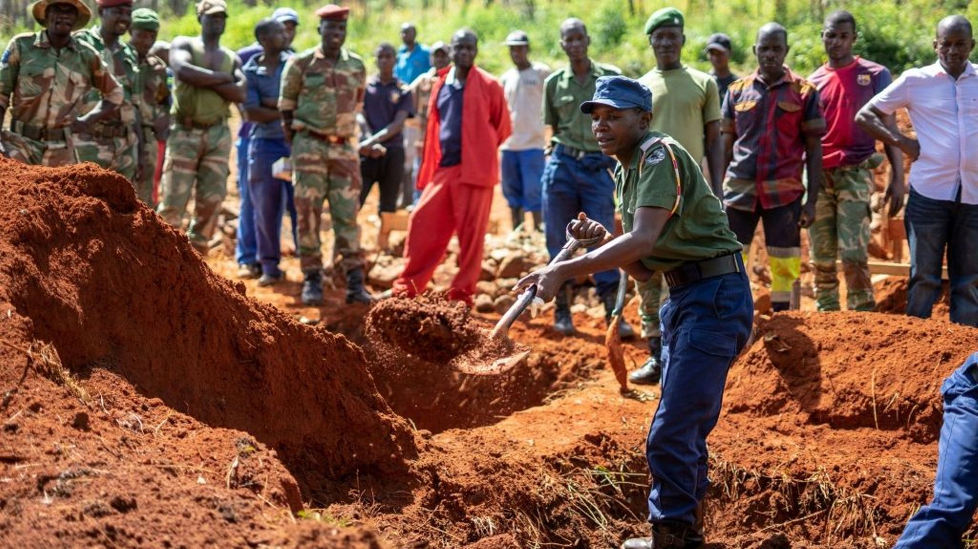 Un policier creuse une tombe collective, le 22 mars 2019 à Chimanimani, au Zimbabwe, le 22 mars 2019