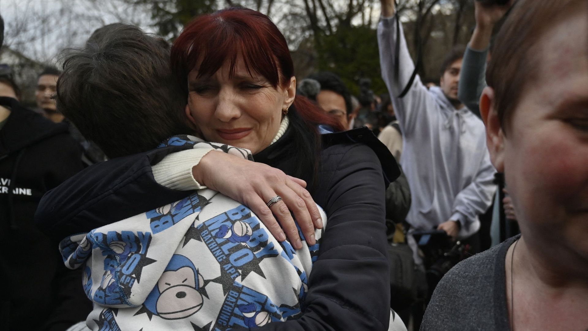Inessa serre son fils Vitaly dans ses bras après l’arrivée à Kiev, le 22 mars 2023, du bus qui les ramenait, lui et plus d’une douzaine d’autres enfants, des territoires tenus par les Russes.