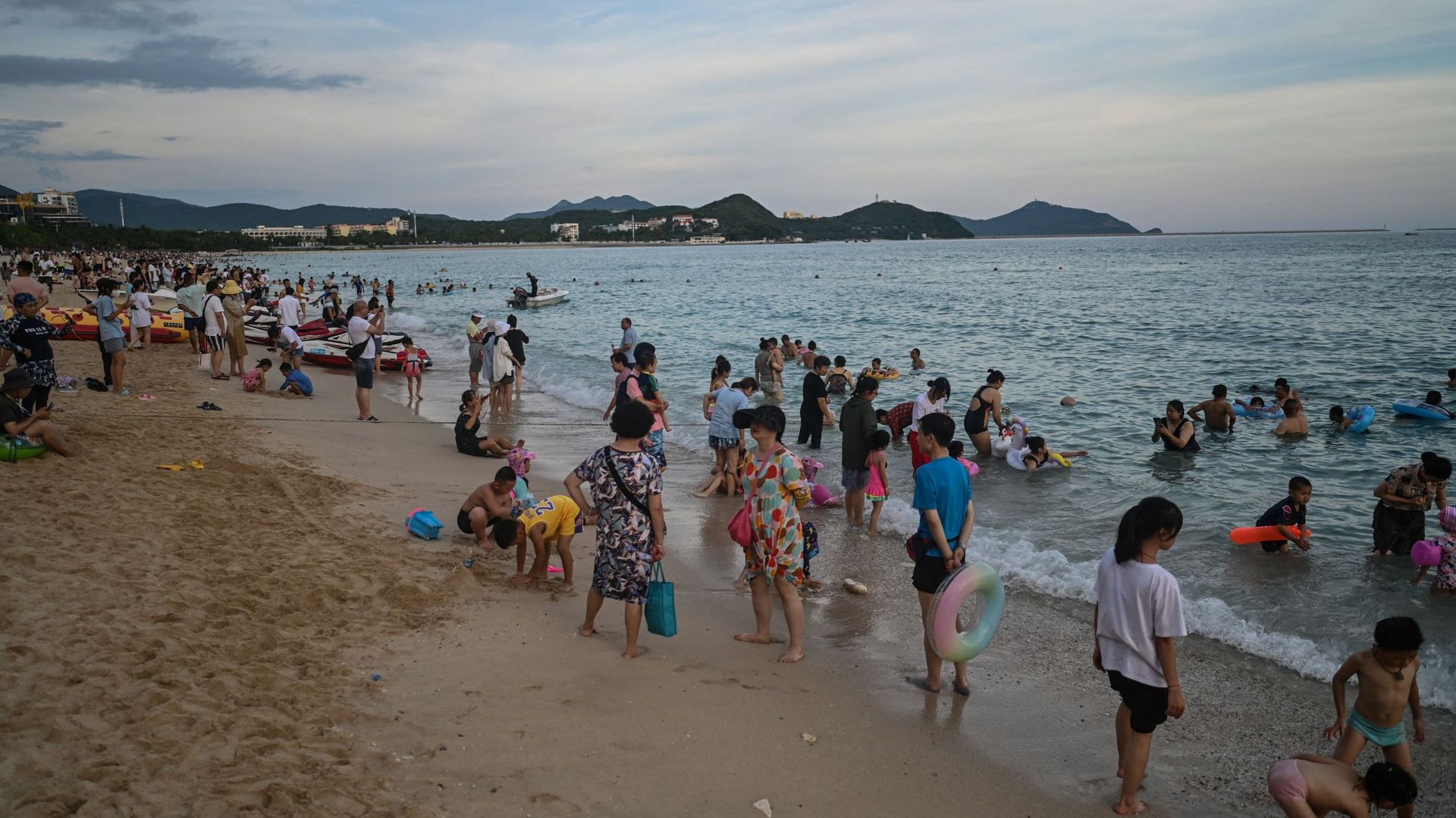 Des gens se baignent sur la plage de Dadonghai à Sanya, sur l'île tropicale de Hainan, en Chine, le 18 juillet 2021. 