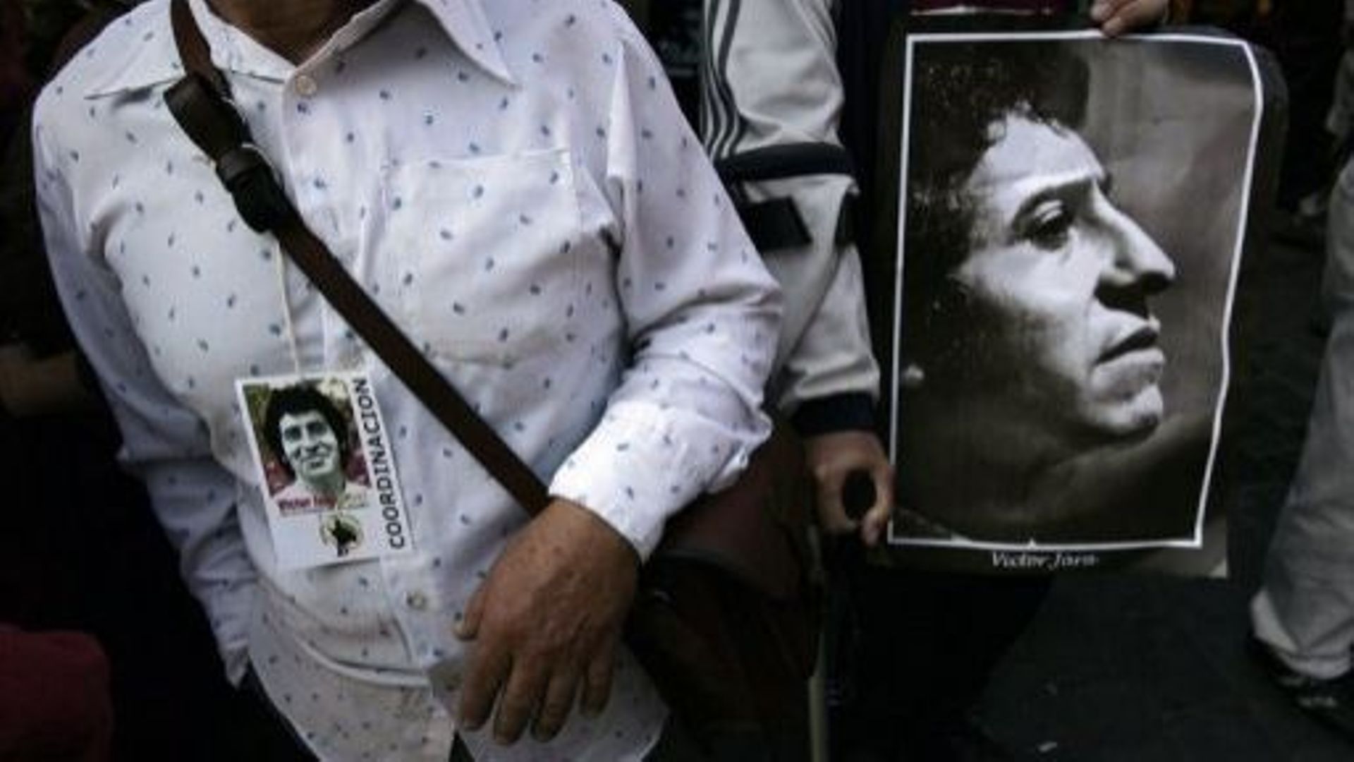 Un homme montre un portrait du chanteur chilien Victor Jara, lors de ses obsèques en 2009 à Santiago