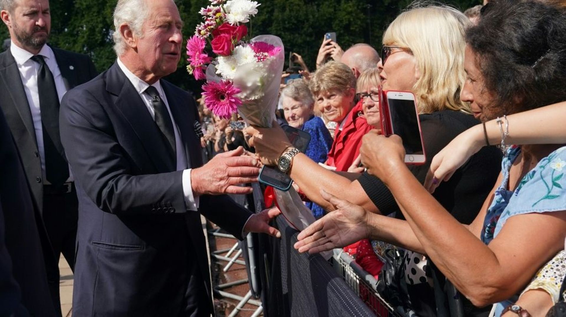 Le roi Charles III salue la foule à son arrivée au palais de Buckhingham, au lendemain du décès de la reine Elizabeth II, le 9 septembre 2022 à Londres
