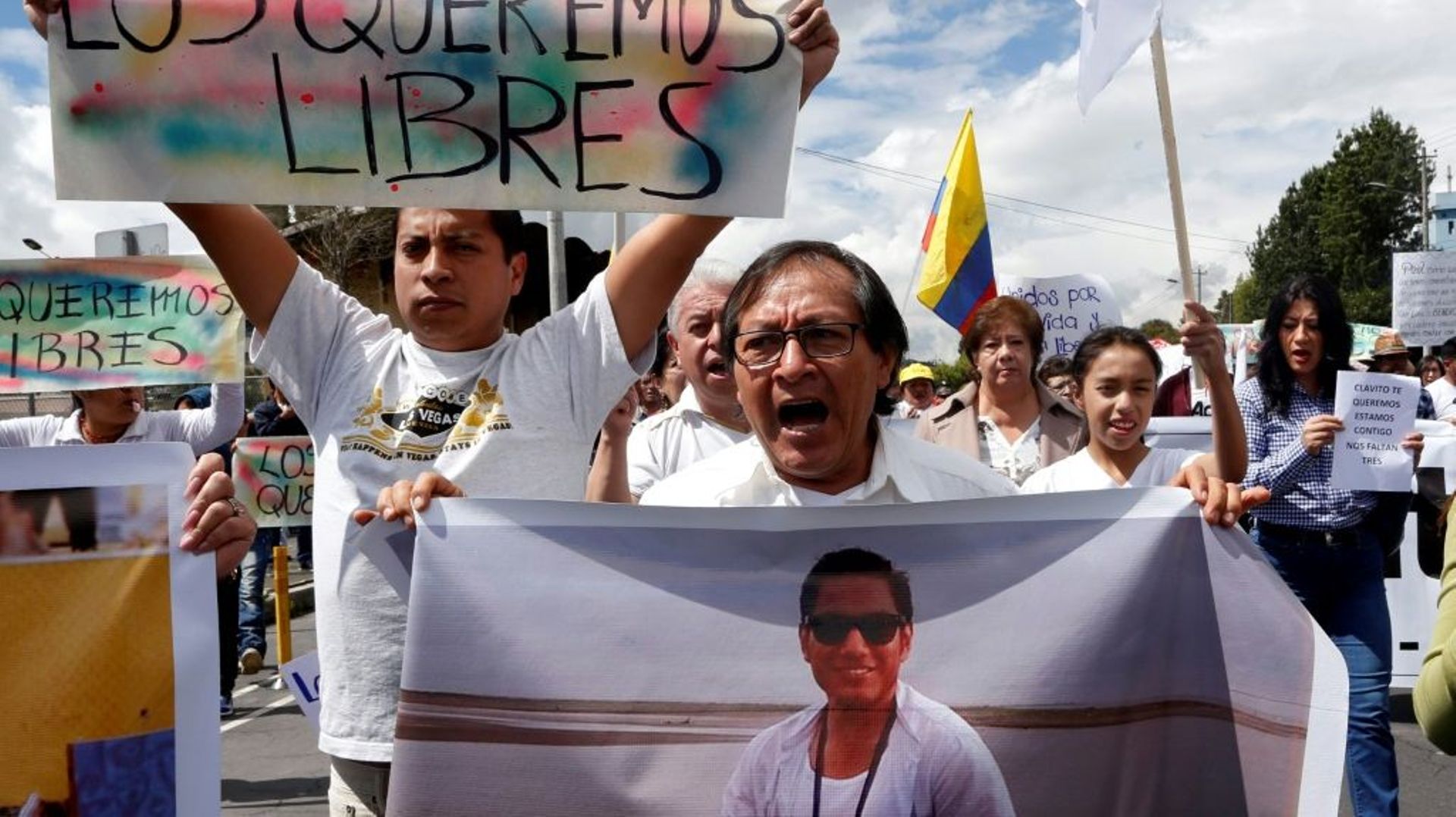 Galo Ortega (à droite) avec une photo de son fils, le journaliste Javier Ortega, pendant une manifestation pour sa libération le 1er avril 2018 à Quito.